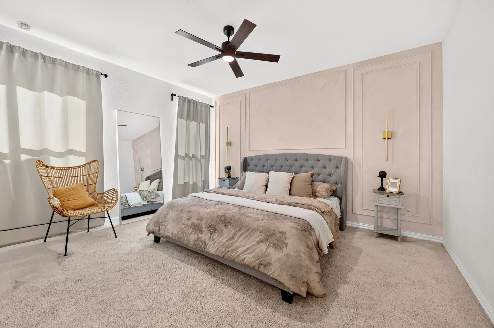 Recessed lighting, ceiling fan, accent wall with panel molding, wall-mounted sconces, and neutral tone carpeting