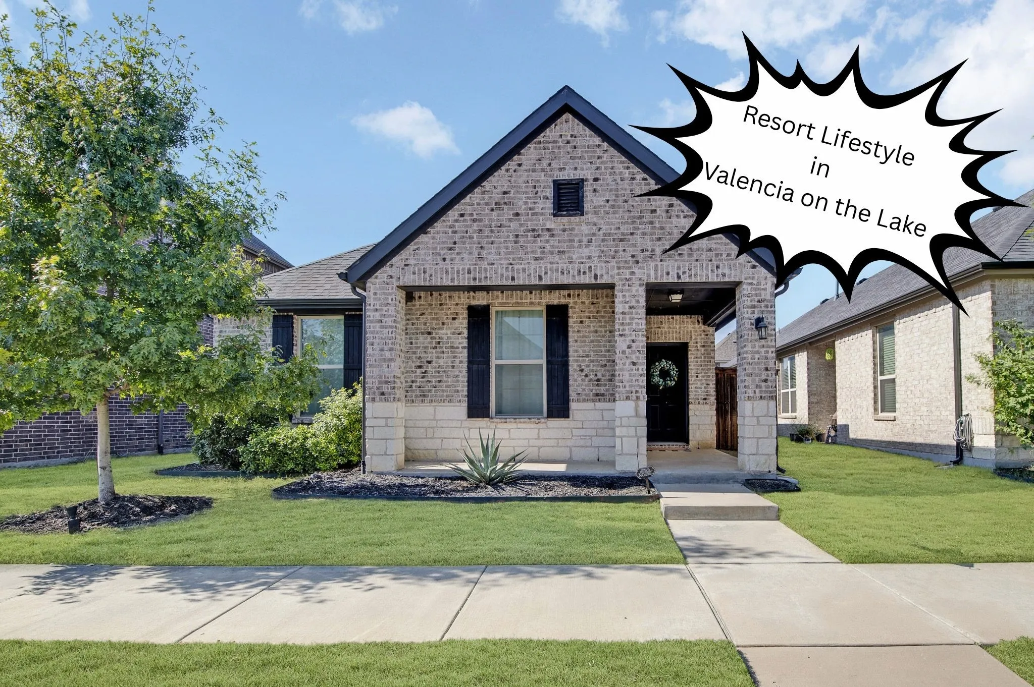 Brick and stone veneer exterior with a covered front porch, black shutters, and an attached roof