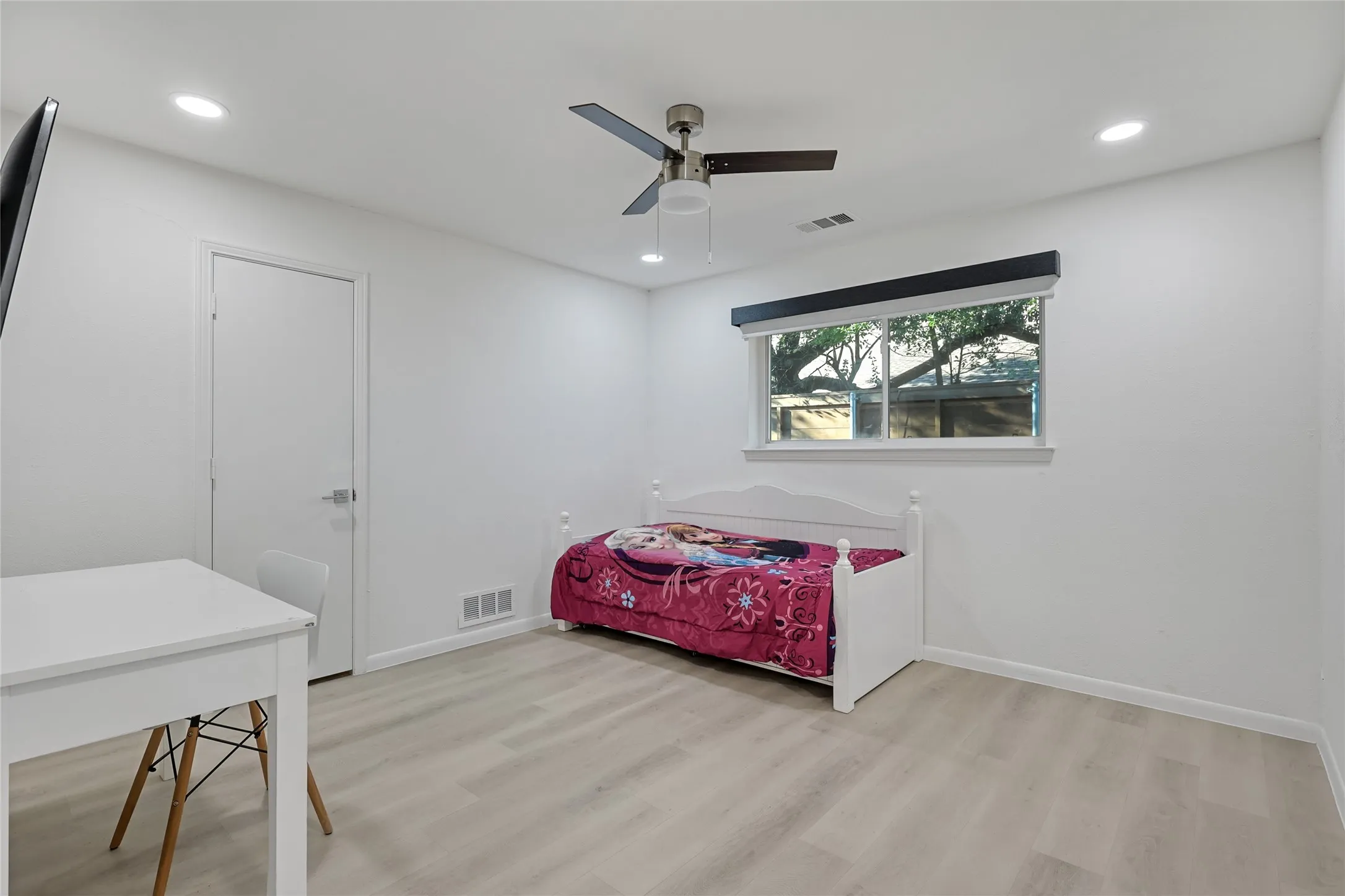 Recessed lighting, ceiling fan, and light wood-finish flooring