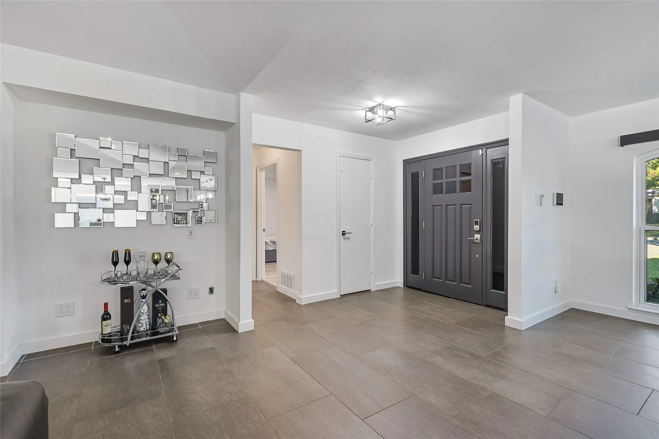 Entryway featuring a Craftsman-style door with sidelights, overhead lighting, wood-finish flooring, and white trim