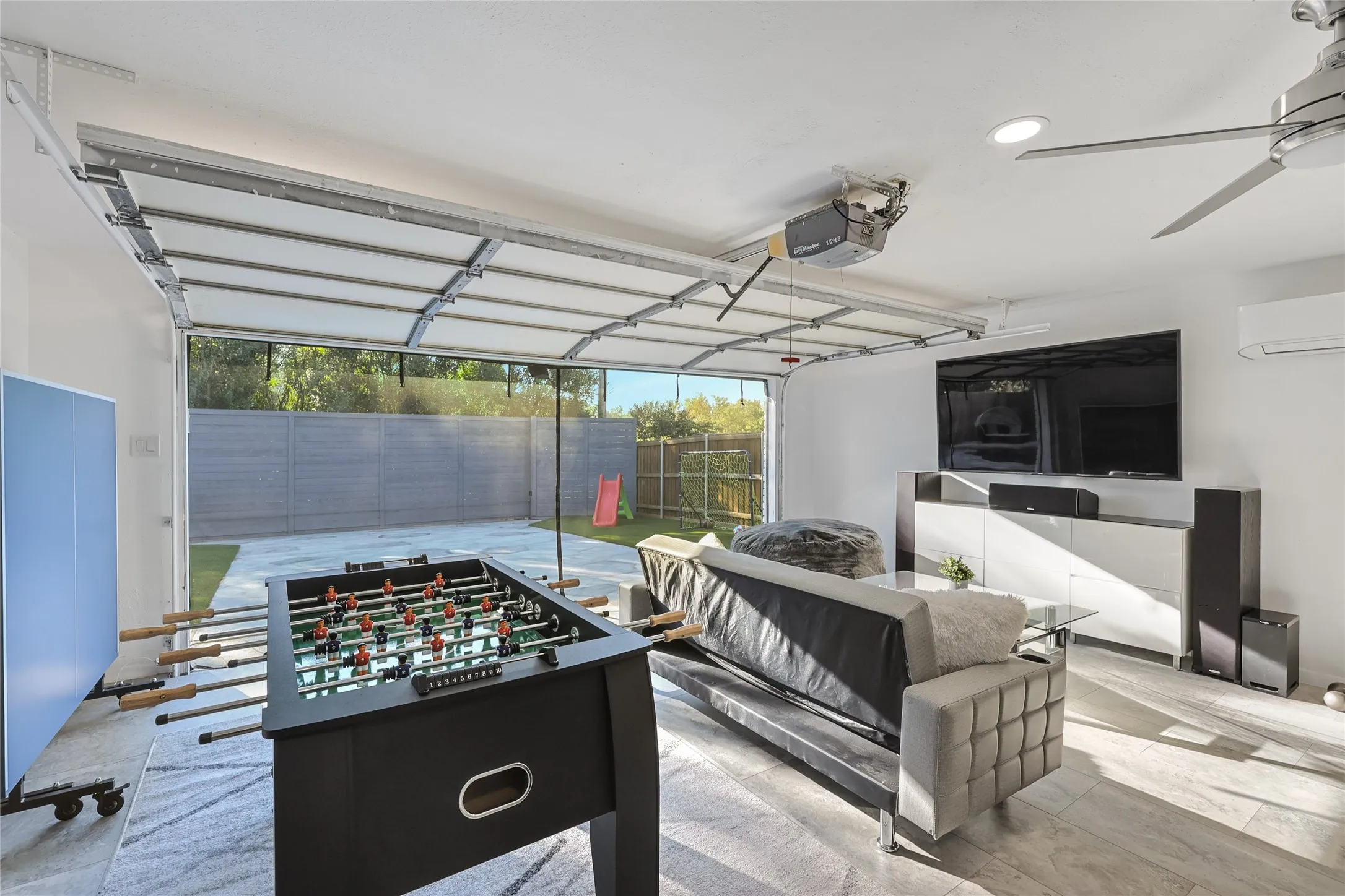 Spacious interior with an overhead garage door, recessed ceiling lighting, a ceiling fan, and light-toned flooring