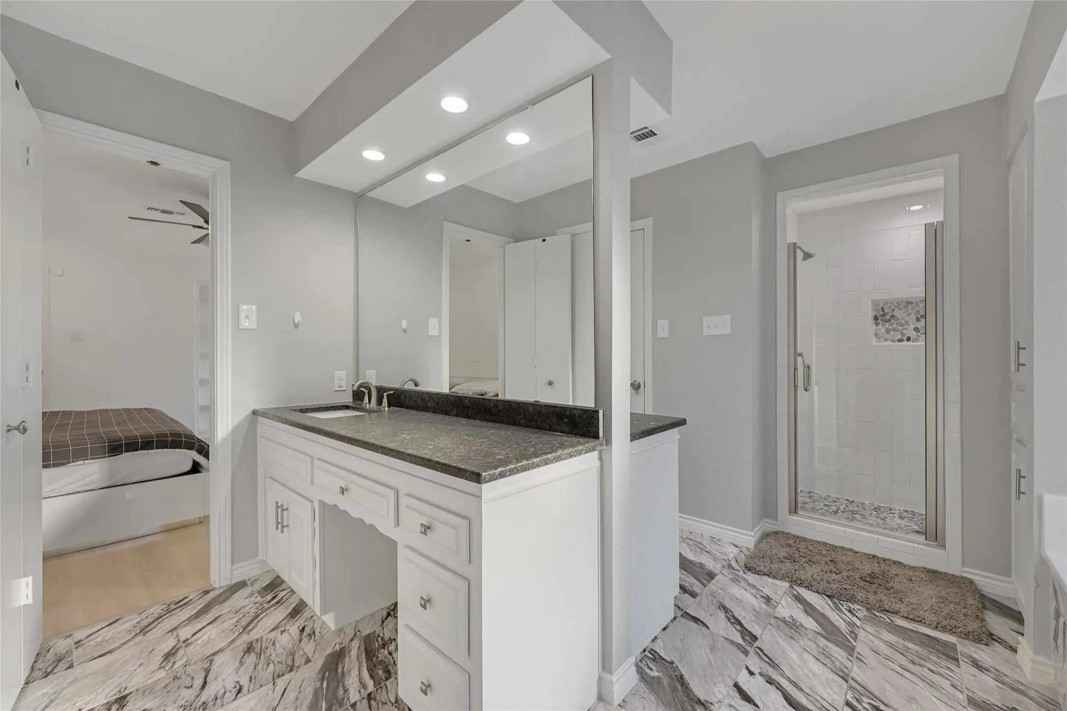 White vanity with a dark countertop and undermount sink