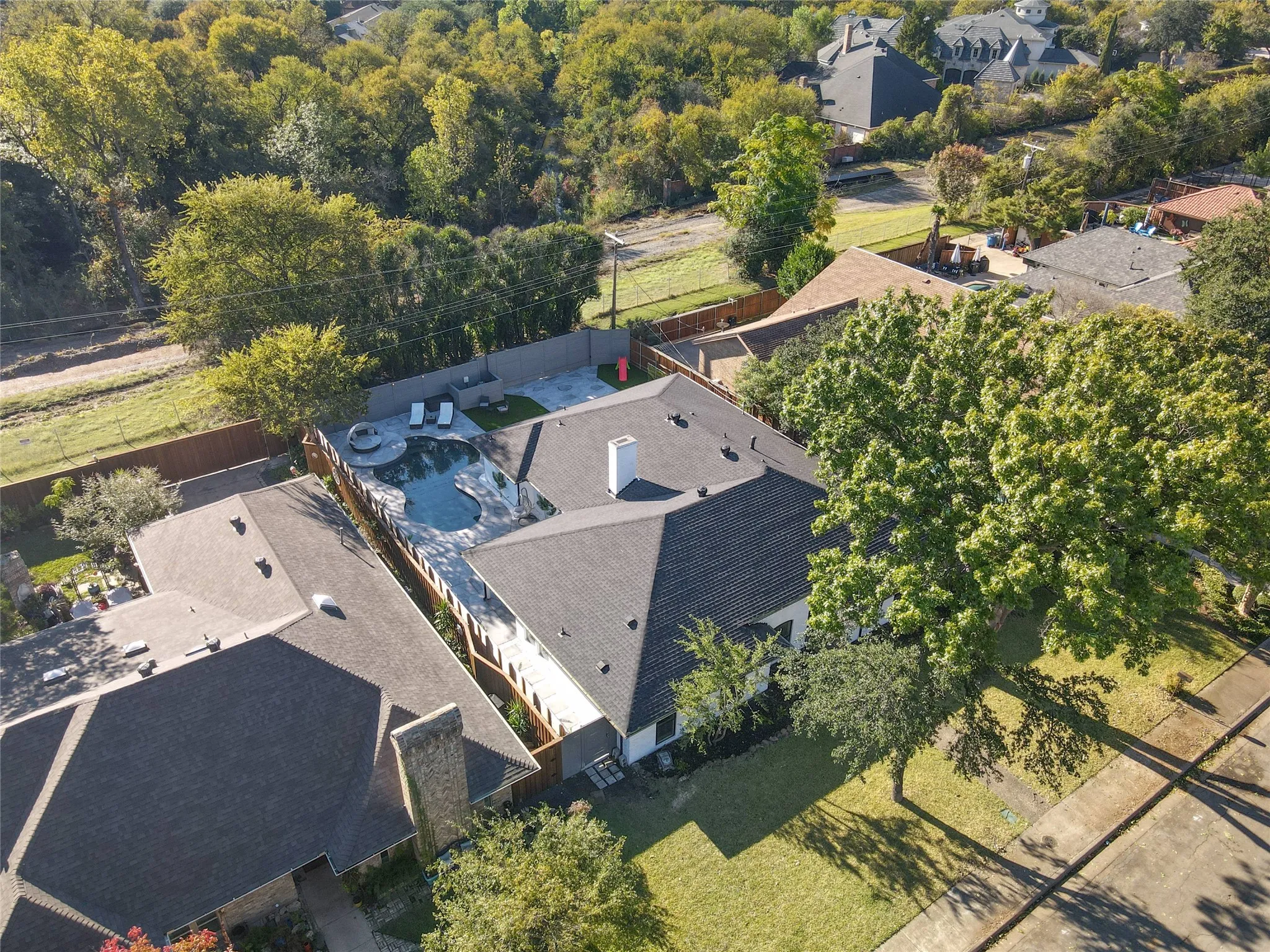 Property featuring an irregularly shaped pool, stone coping, and a surrounding patio