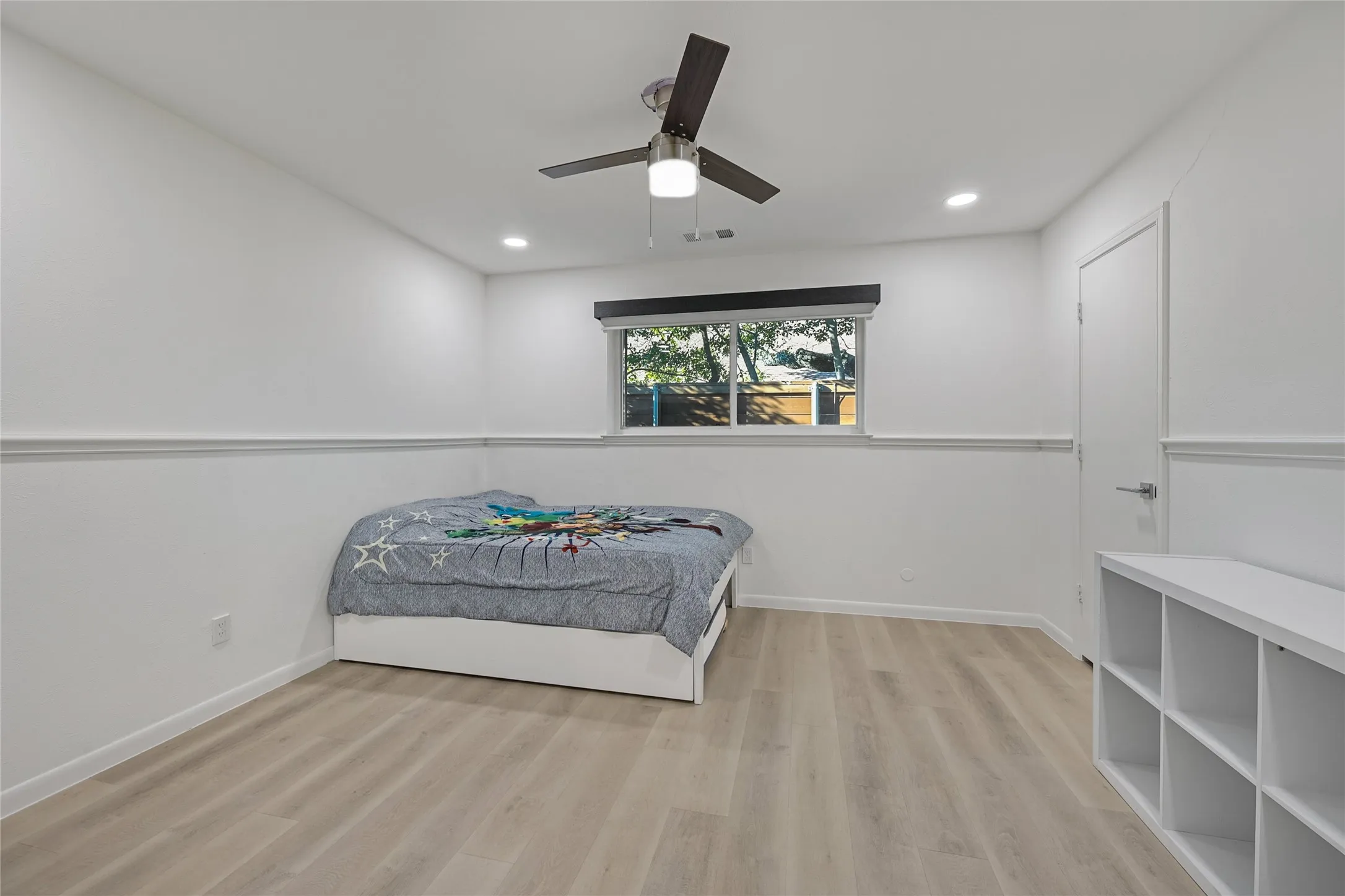 Recessed lighting, wood-finish flooring, ceiling fan, and white trim