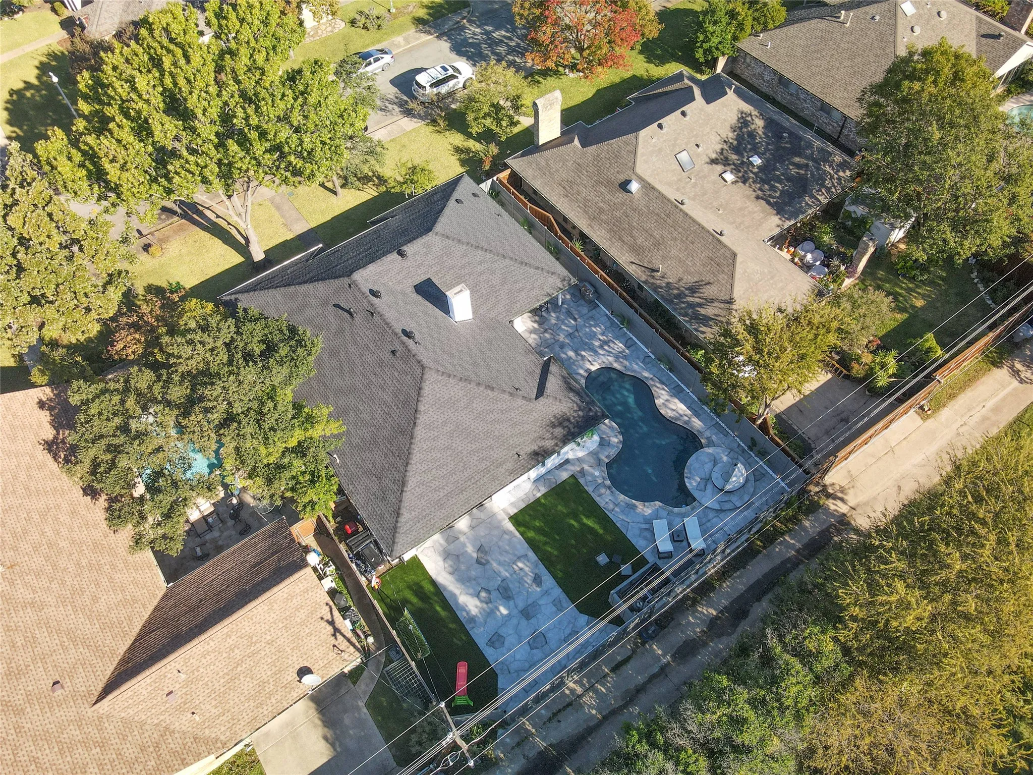 Shingle roof, swimming pool, extensive hardscaping, artificial turf, and mature trees