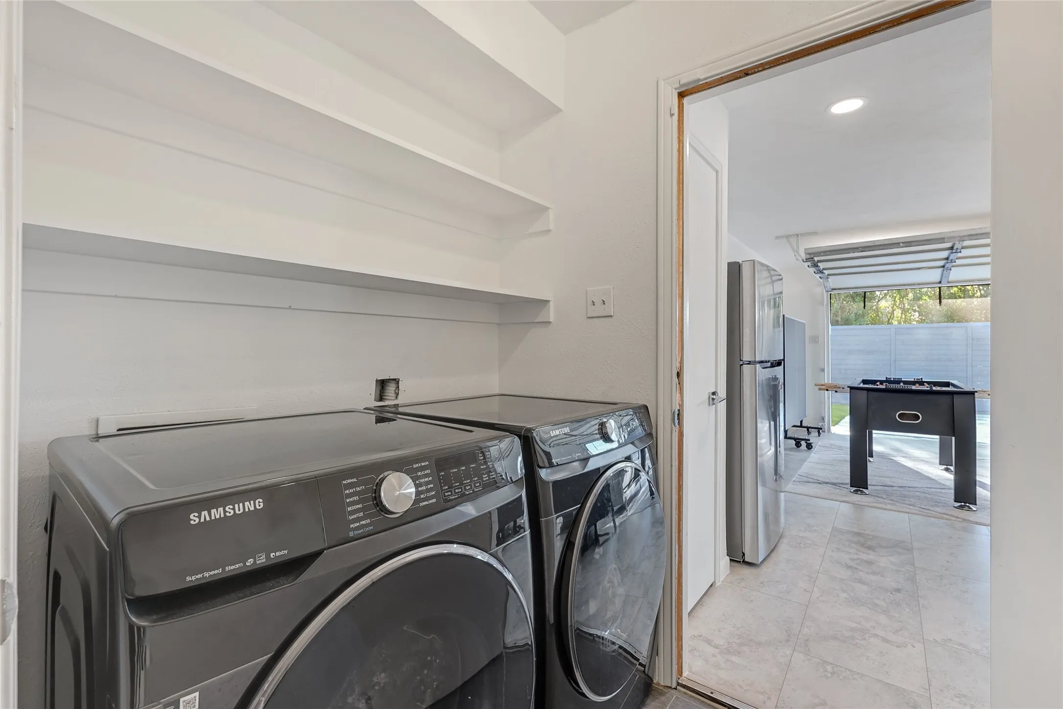 Utility area with built-in shelving, tile flooring, and a flush-mount overhead light fixture
