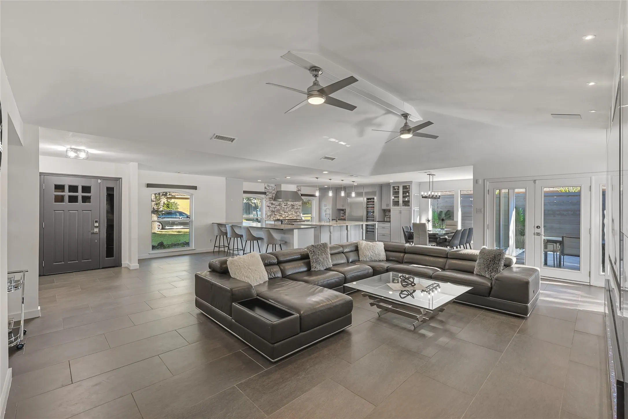 Vaulted ceilings with recessed lighting, tile flooring, and French doors