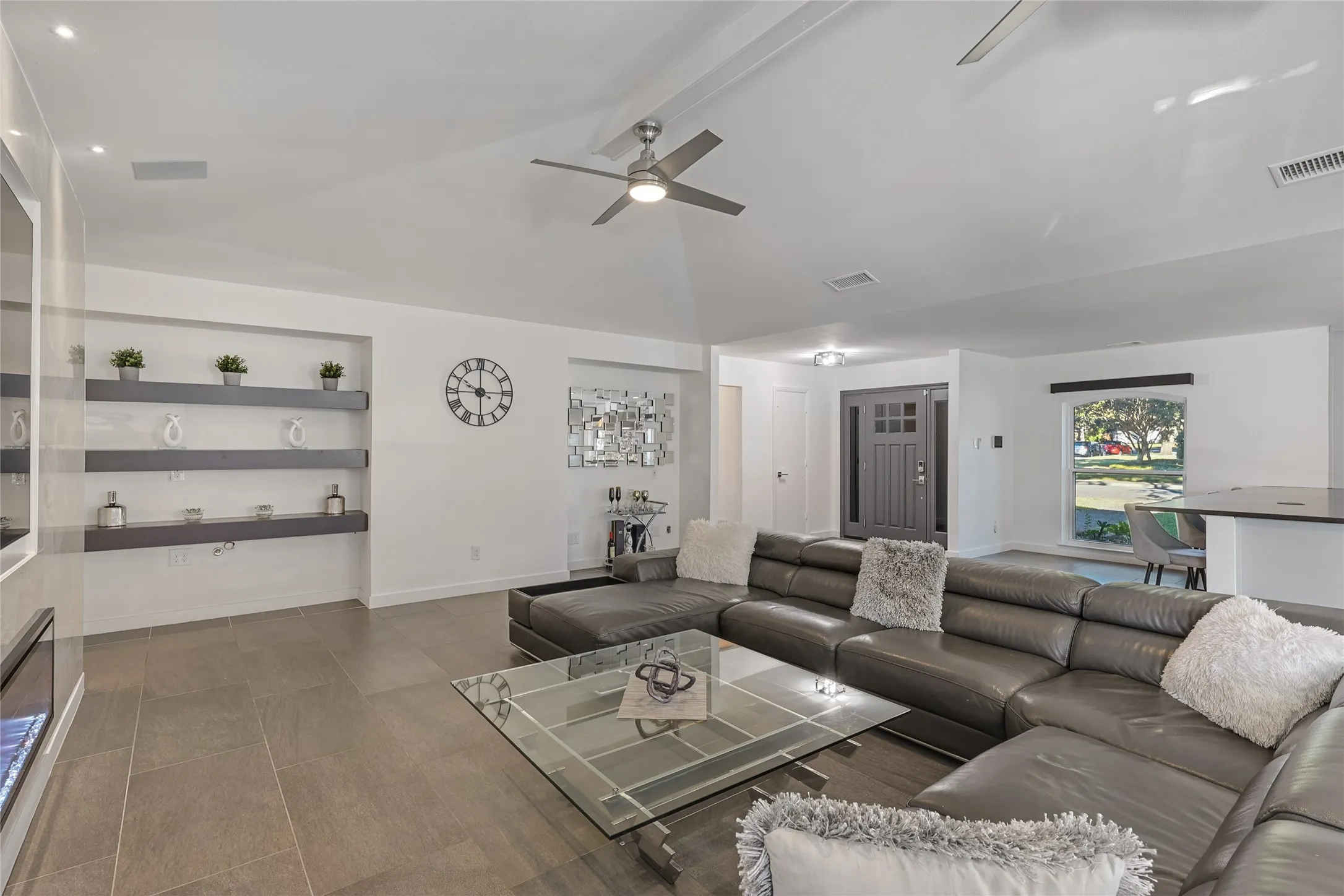 Vaulted ceilings with recessed lighting, built-in shelving, tile flooring, and a ceiling fan