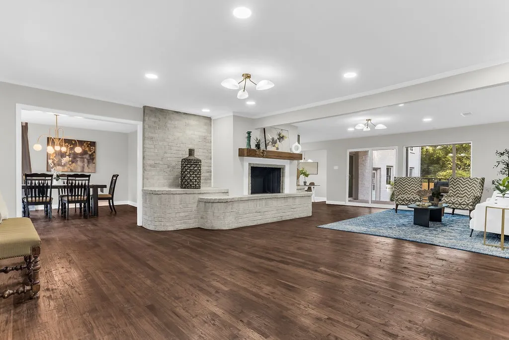 Great room with hardwood floors, recessed lighting and whitewashed brick fireplace wall