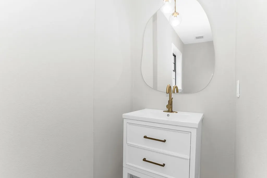 Half bath with vanity and brass fixtures