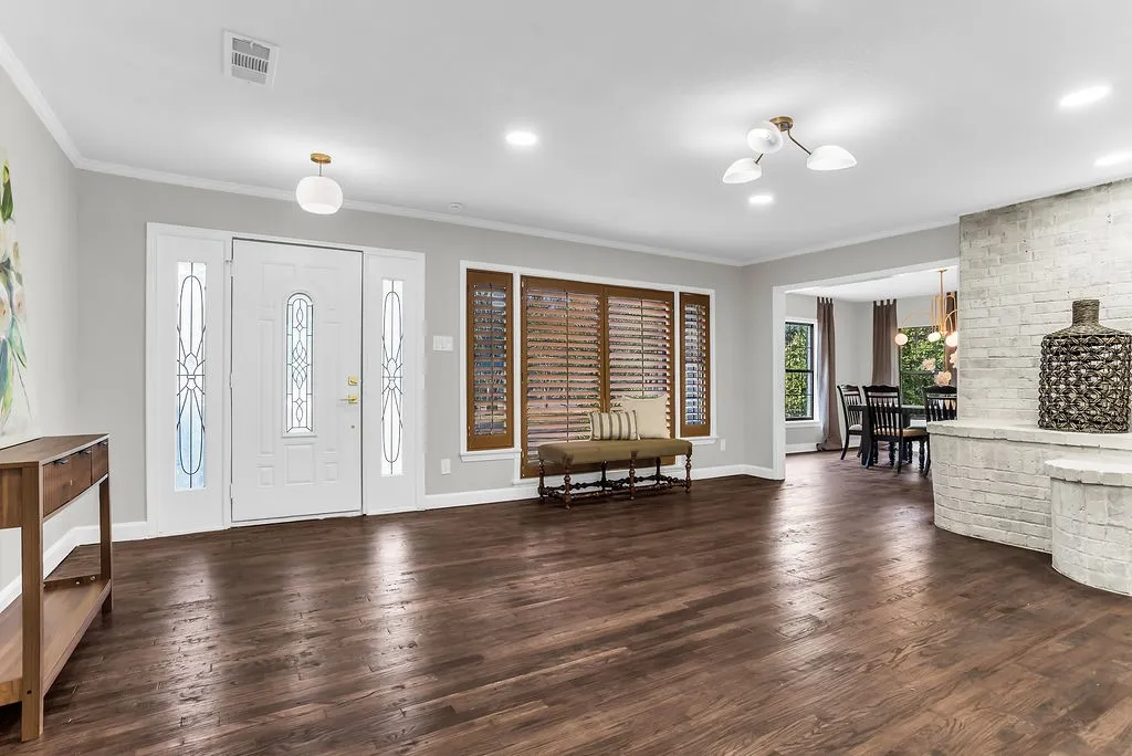 Entry with hardwood floors, plantation shutters and leaded-glass front door with sidelights