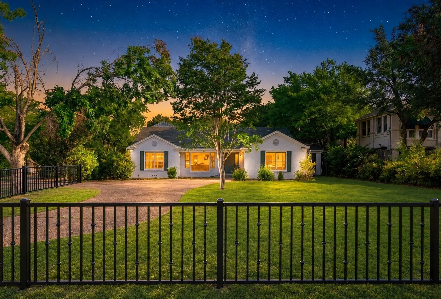 Front exterior at twilight with the new black metal fence