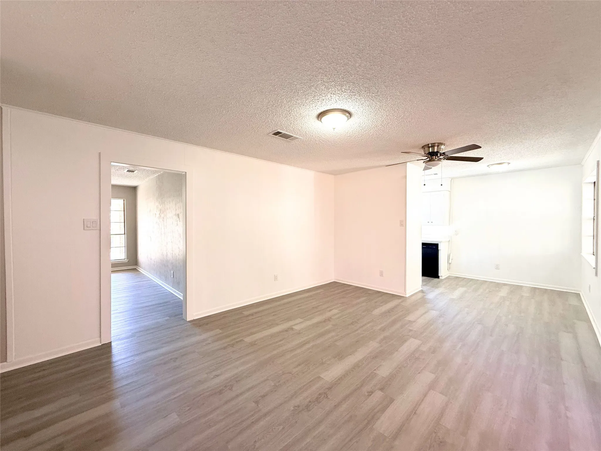 Expansive interior featuring wood-finish flooring, a ceiling fan, and recessed lighting