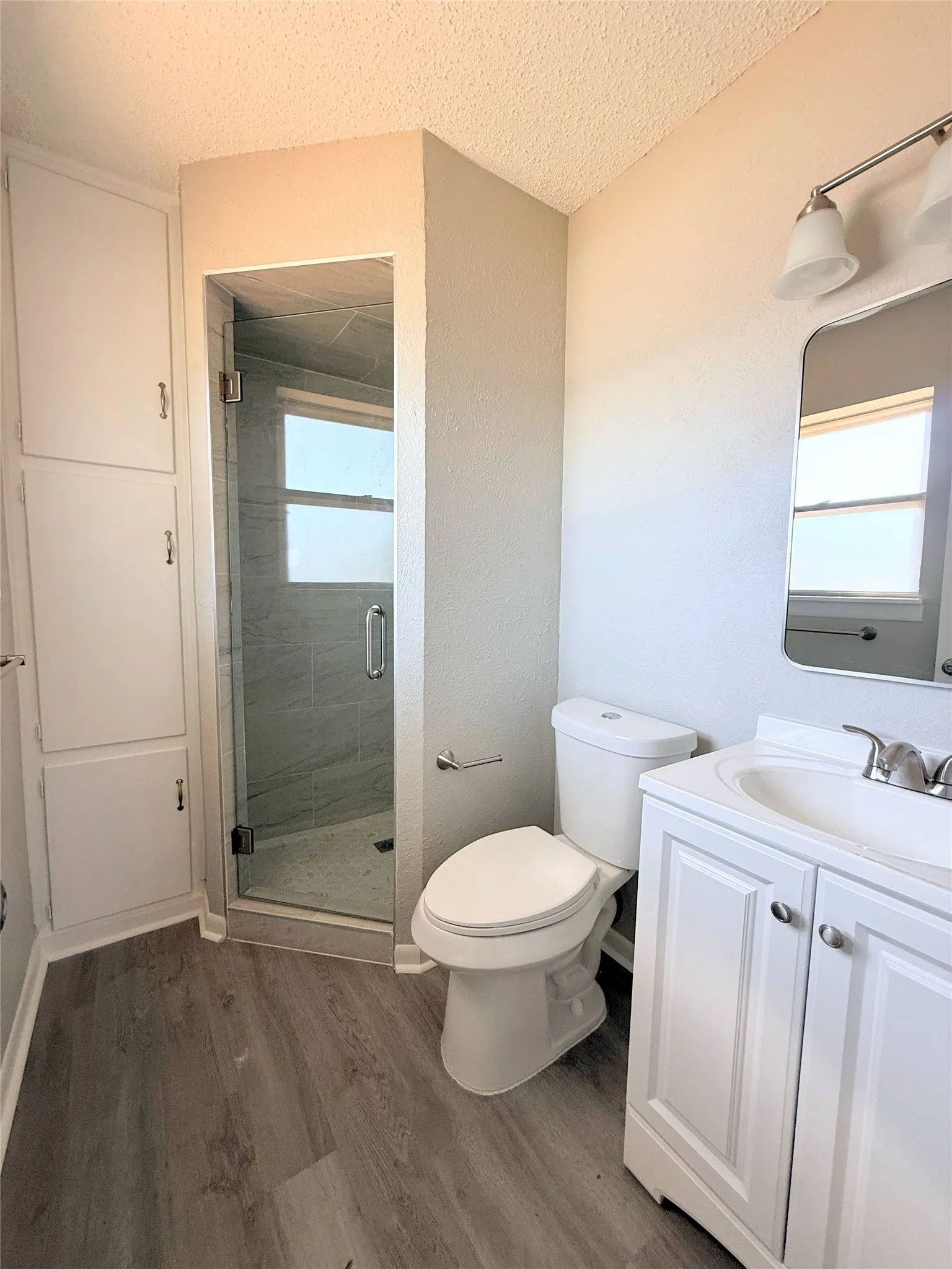 Glass-enclosed shower with tiled walls and a built-in window