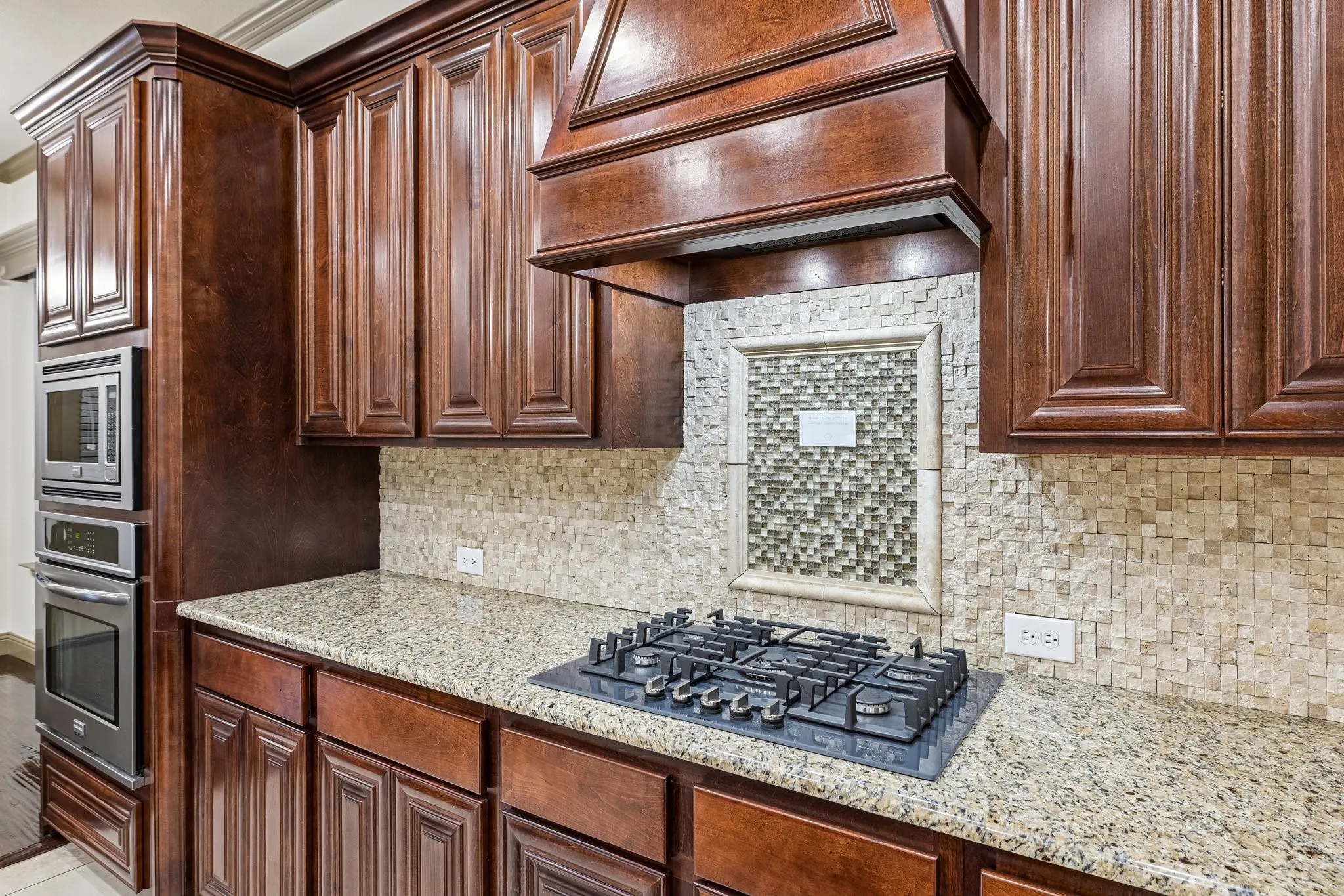 Rich wood cabinetry, integrated Bosch 5 burner Gas cooktop. Push to open and close drawers.