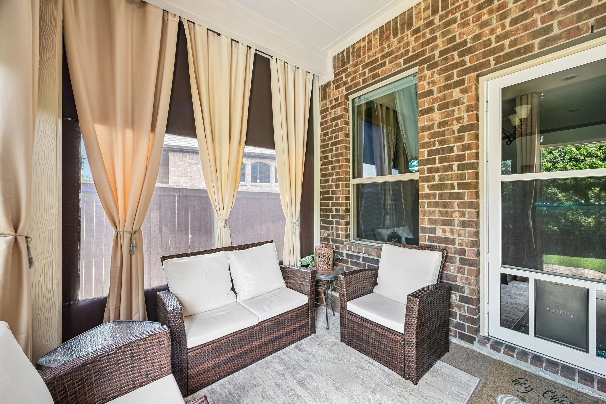 Covered patio with brick exterior and privacy/bug screening