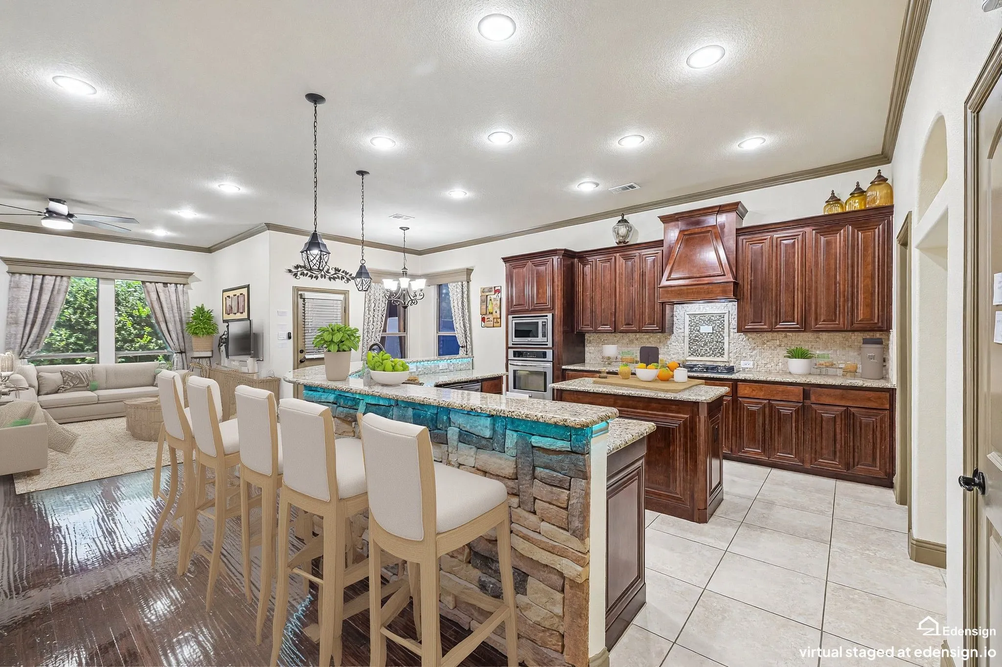 Kitchen featuring wood cabinetry, granite. countertops, an integrated oven and microwave, and a stone-clad island with a raised bar. Virtually Staged.