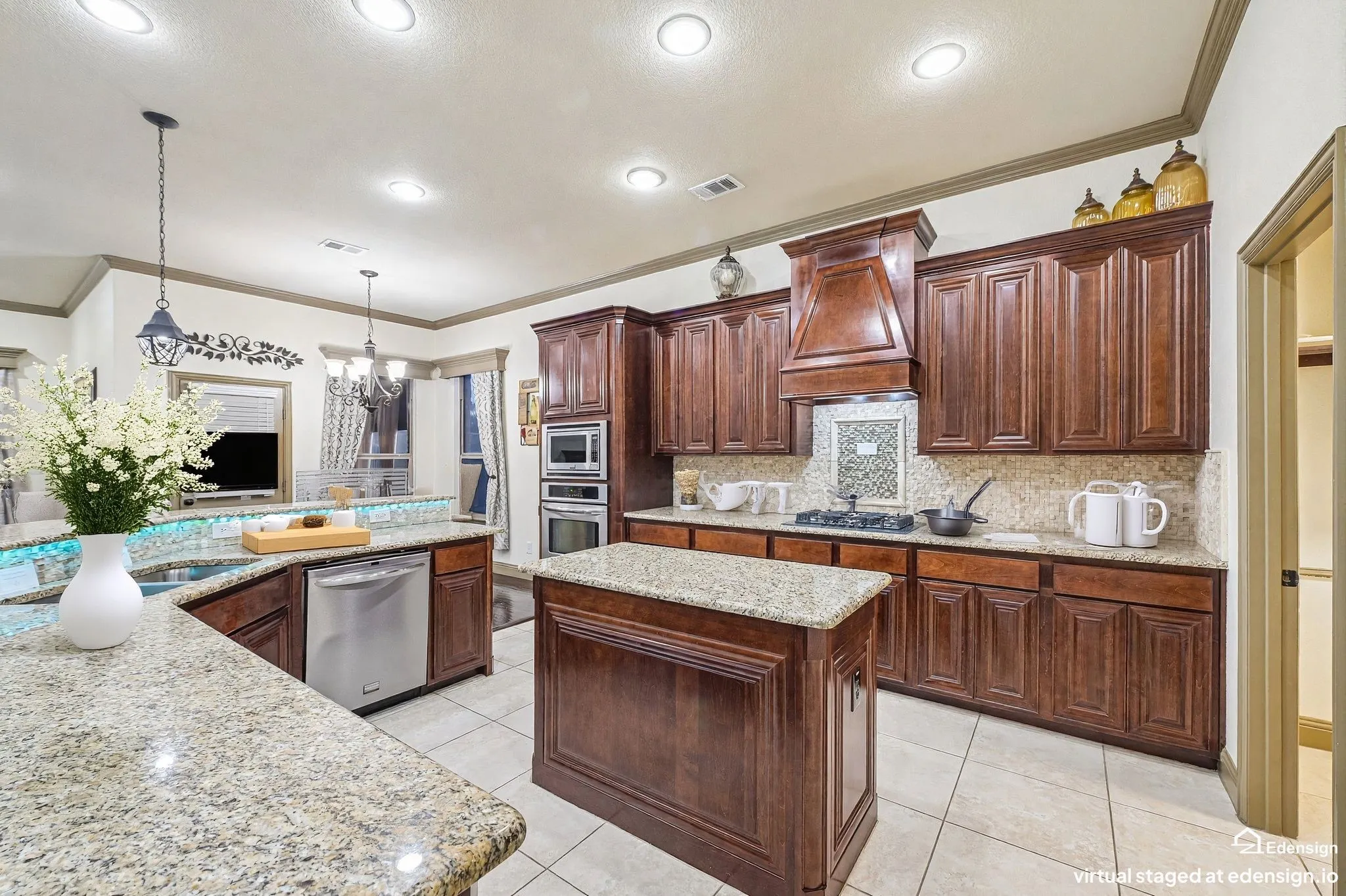 Gourmet kitchen featuring rich wood cabinetry, dual islands with stone countertops, stainless steel appliances, decorative tile backsplash, recessed lighting, and ceramic tile flooring throughout the open layout. Virtually Staged.