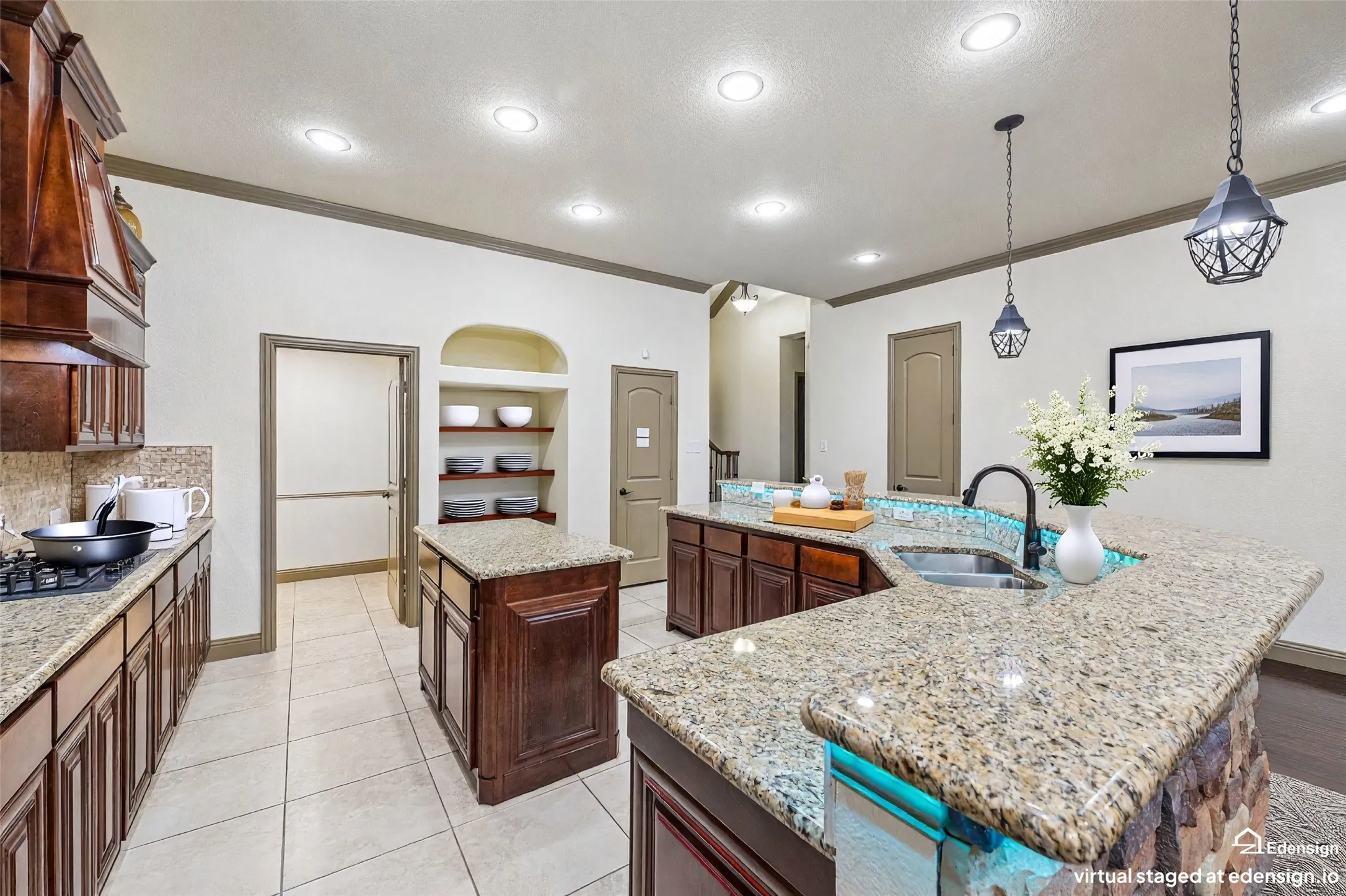 Gourmet kitchen featuring dual islands with granite countertops, dark wood cabinetry, stainless steel appliances, recessed ceiling lighting, and pendant fixtures. Virtually Staged.