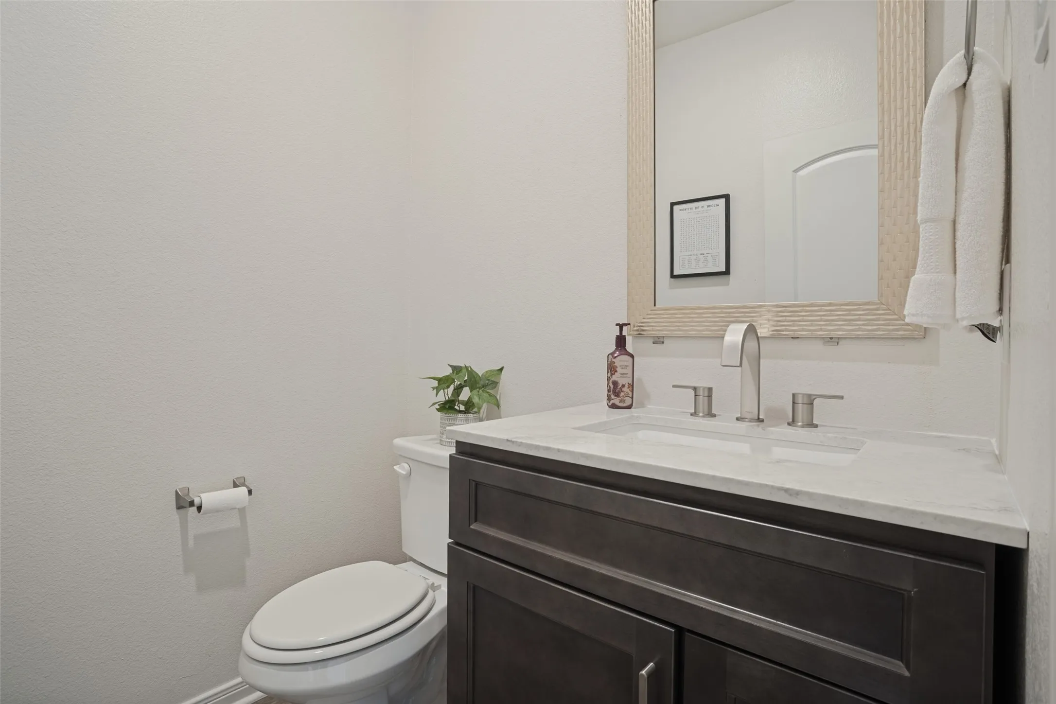 Dark wood-finish vanity with a white countertop and undermount sink