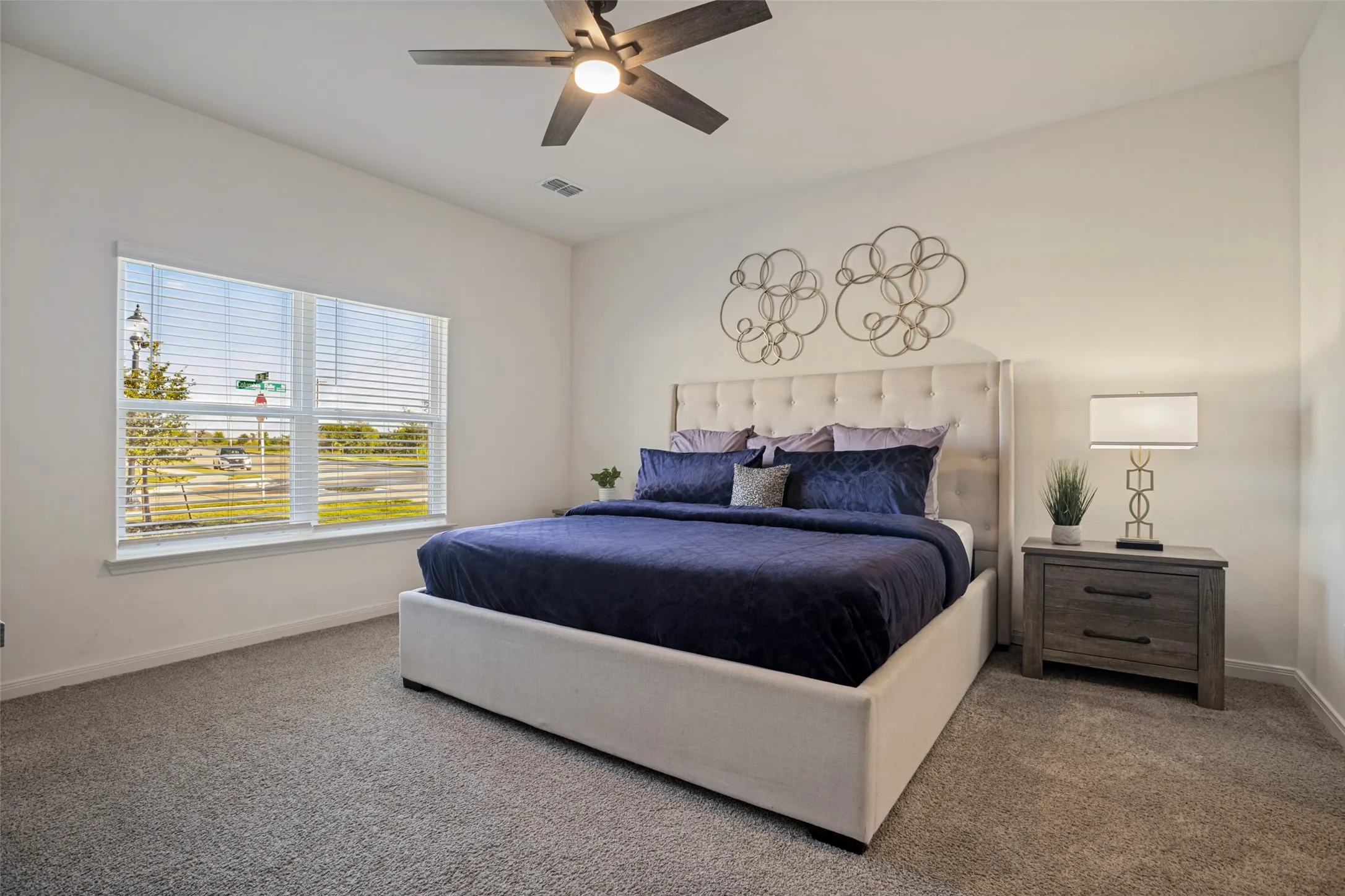 Recessed lighting, ceiling fan with integrated light, large window with blinds, and neutral carpet