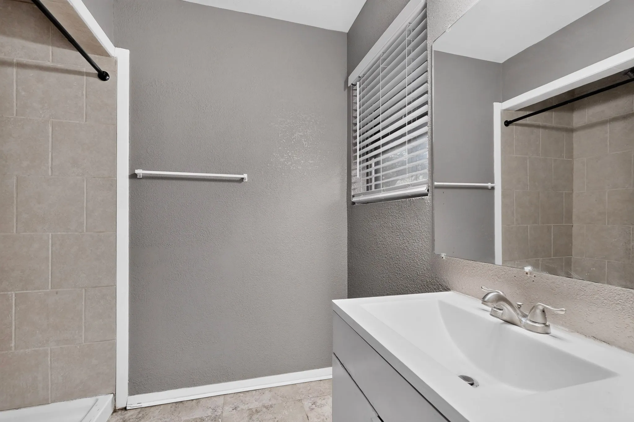 Recessed shower with tiled surround and black shower rod
