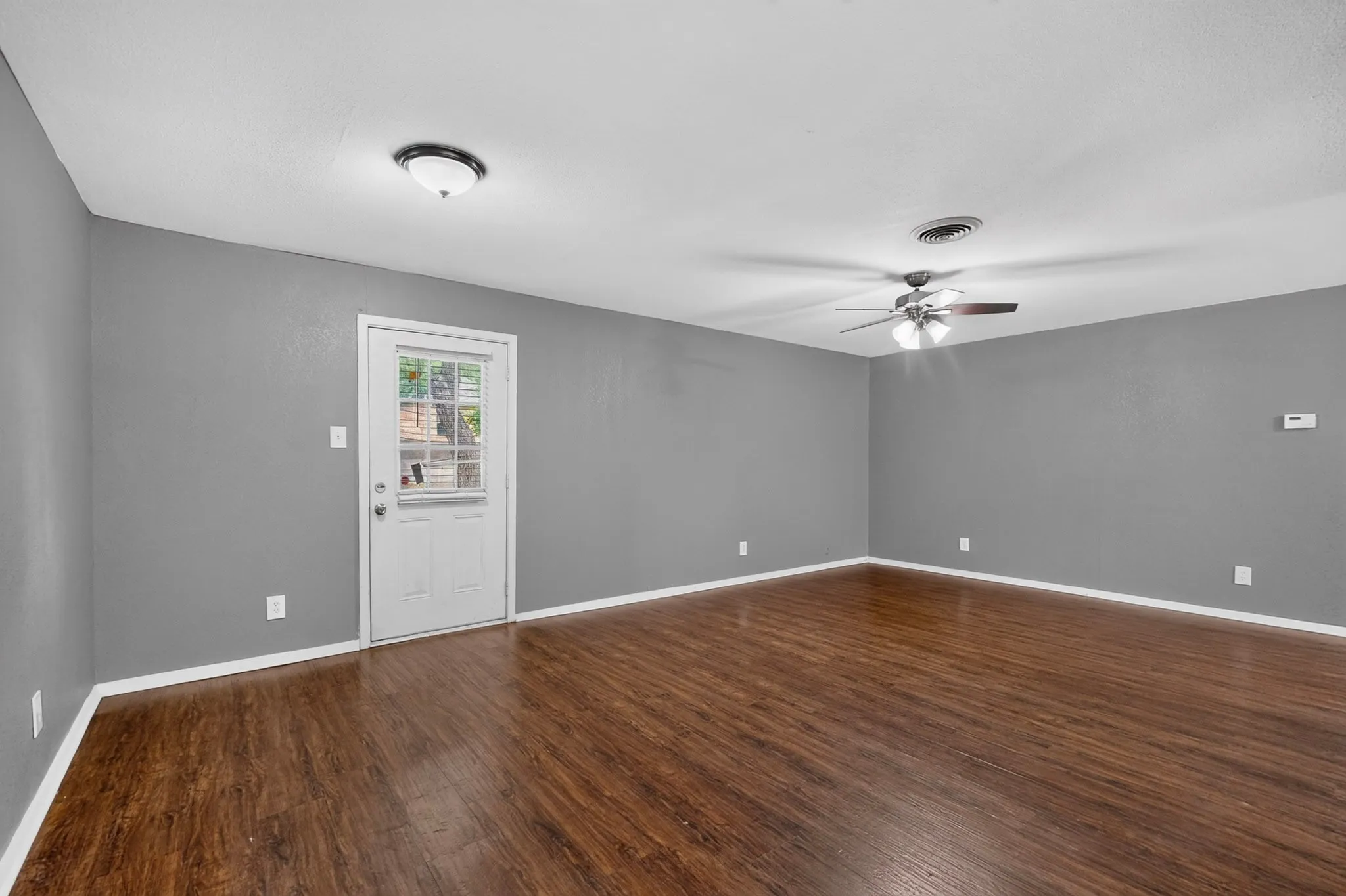 Wood-finish flooring, ceiling fan with light, recessed lighting, and a white paneled door with window inserts