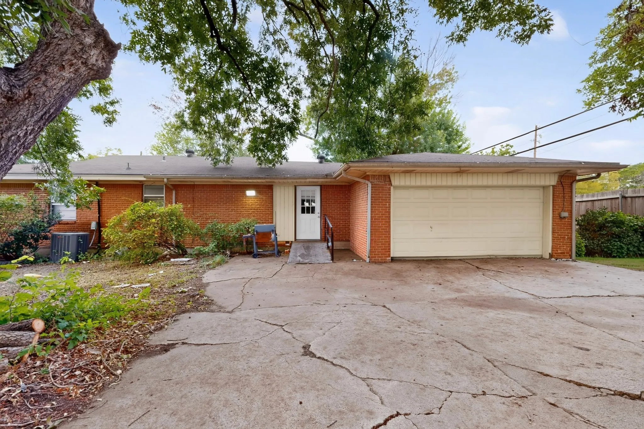 Brick exterior with an attached garage, white garage door, and a white entry door