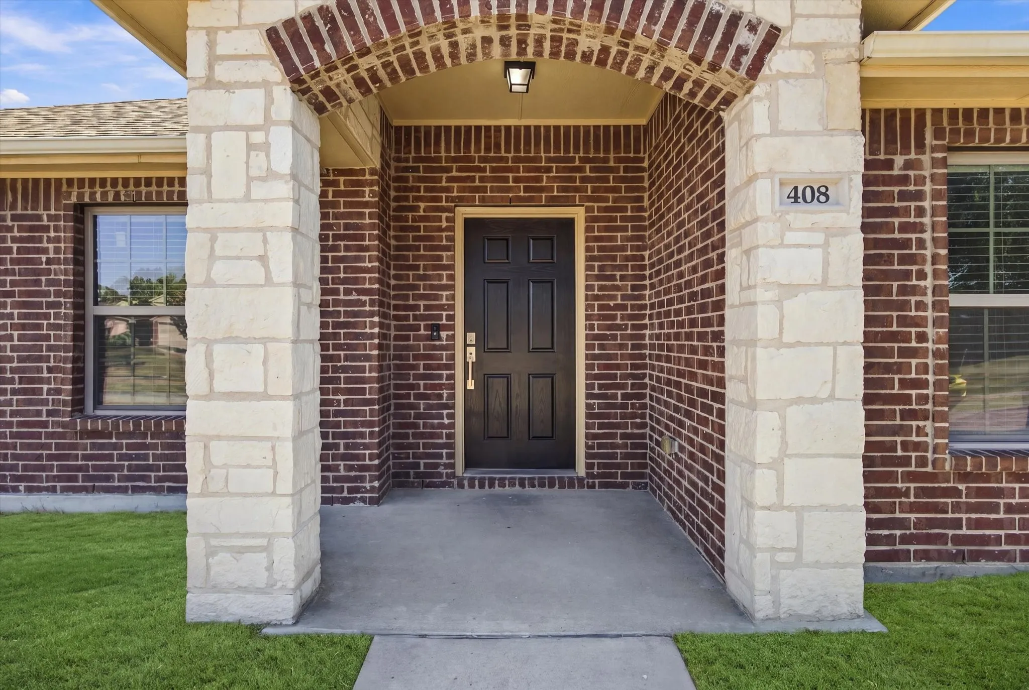 Brick and stone exterior with a covered entry