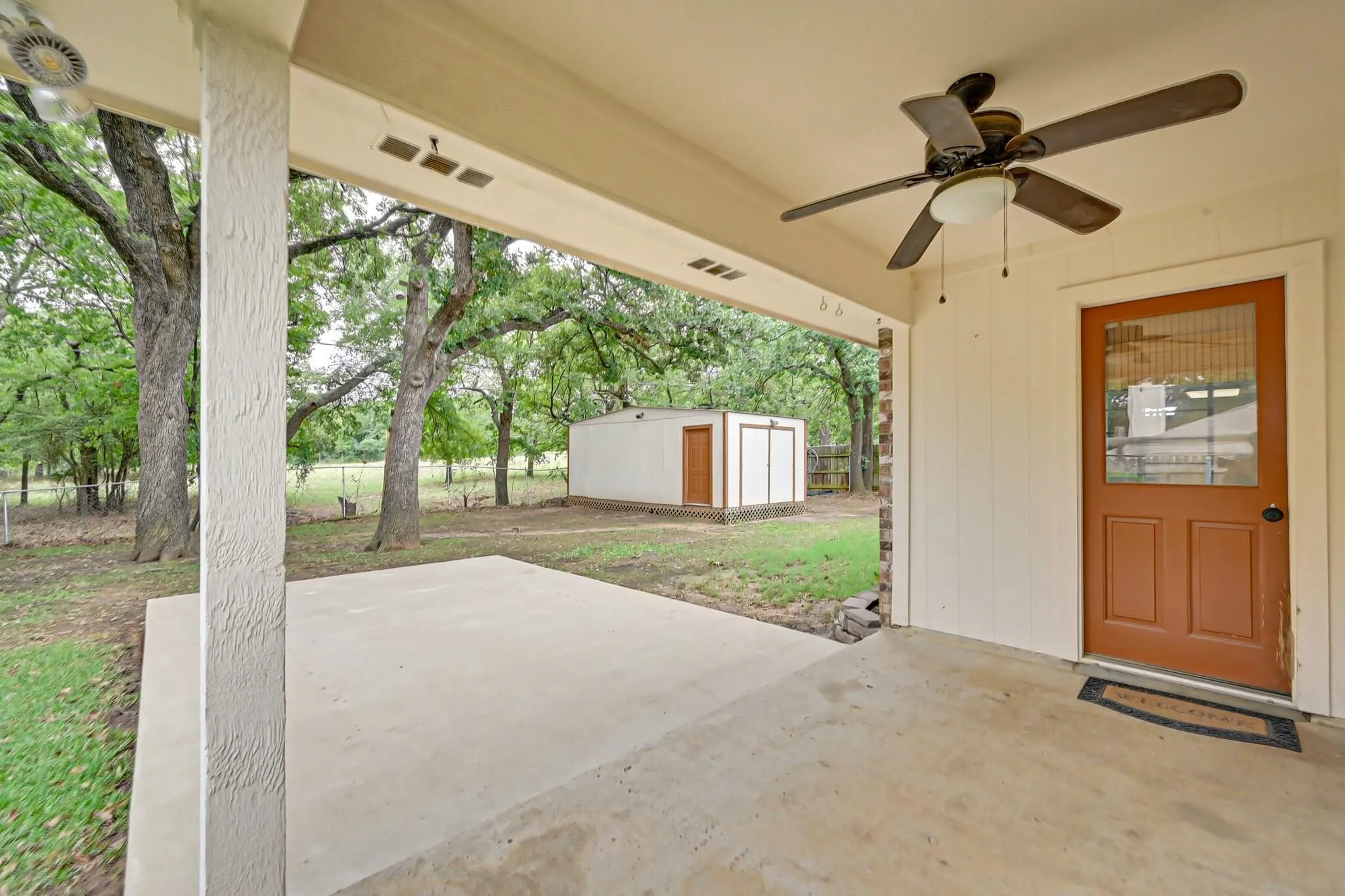 Covered concrete patio with a ceiling fan