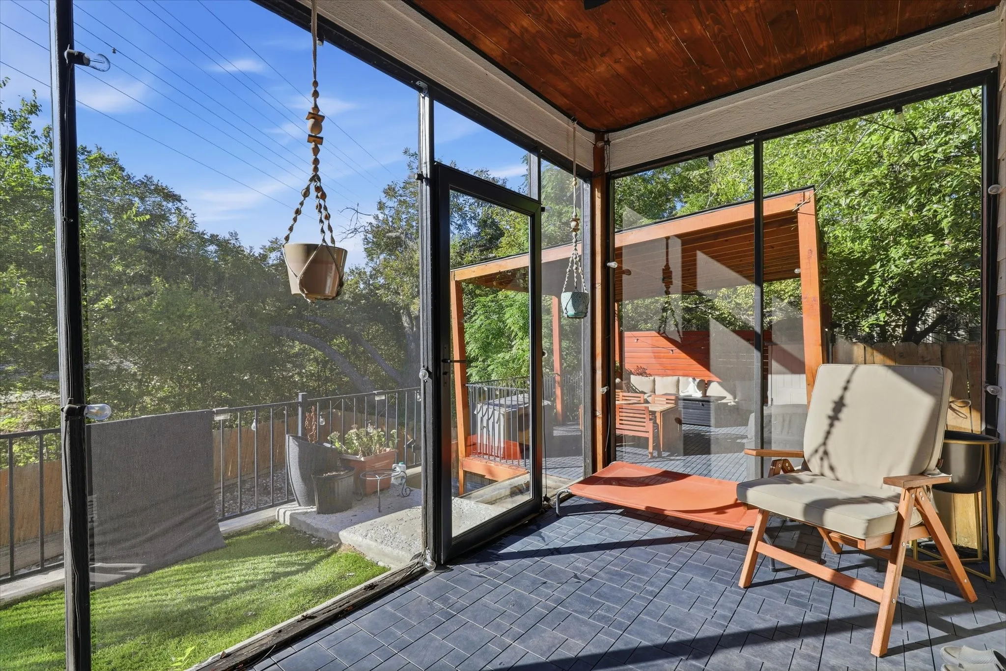 Screened-in porch featuring a wood-panel ceiling, patterned flooring, and direct access to an outdoor deck