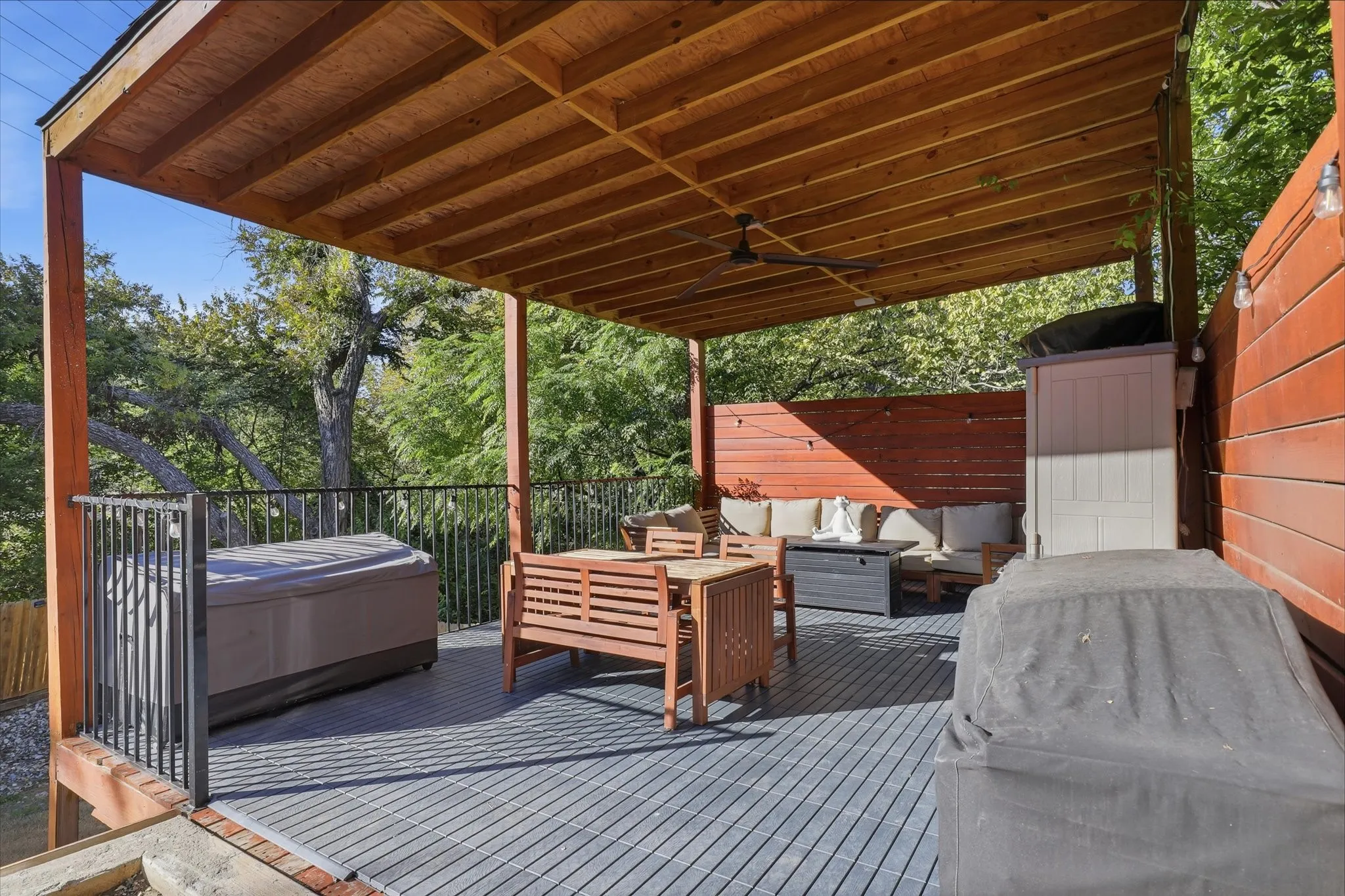 Expansive covered deck with composite decking, slatted wood ceiling, and integrated ceiling fan