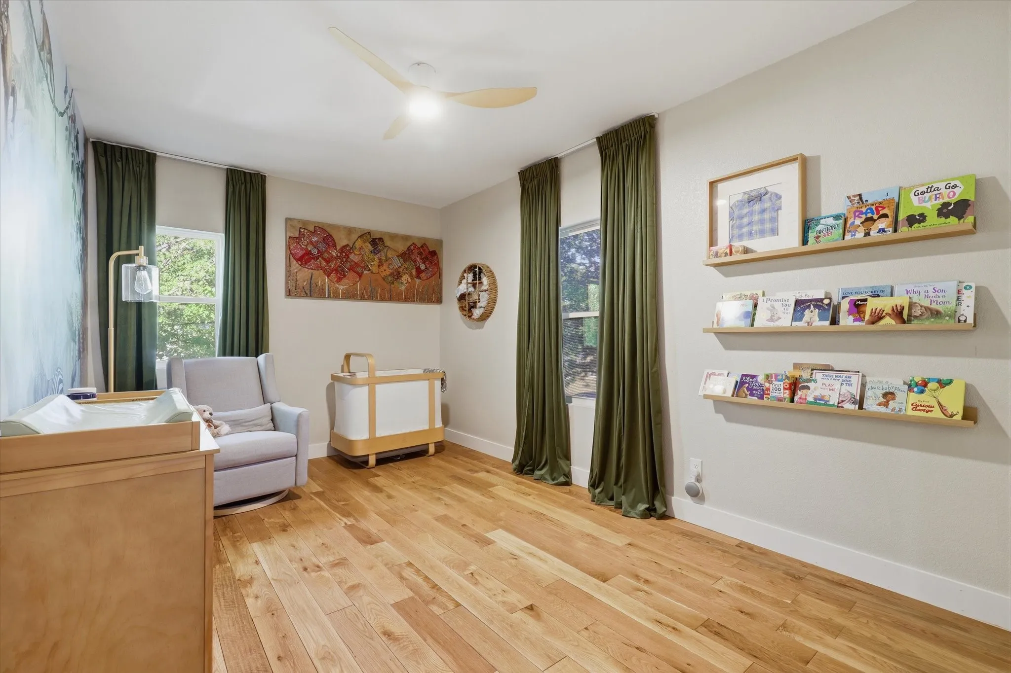 Recessed lighting and a ceiling fan illuminate the light wood flooring