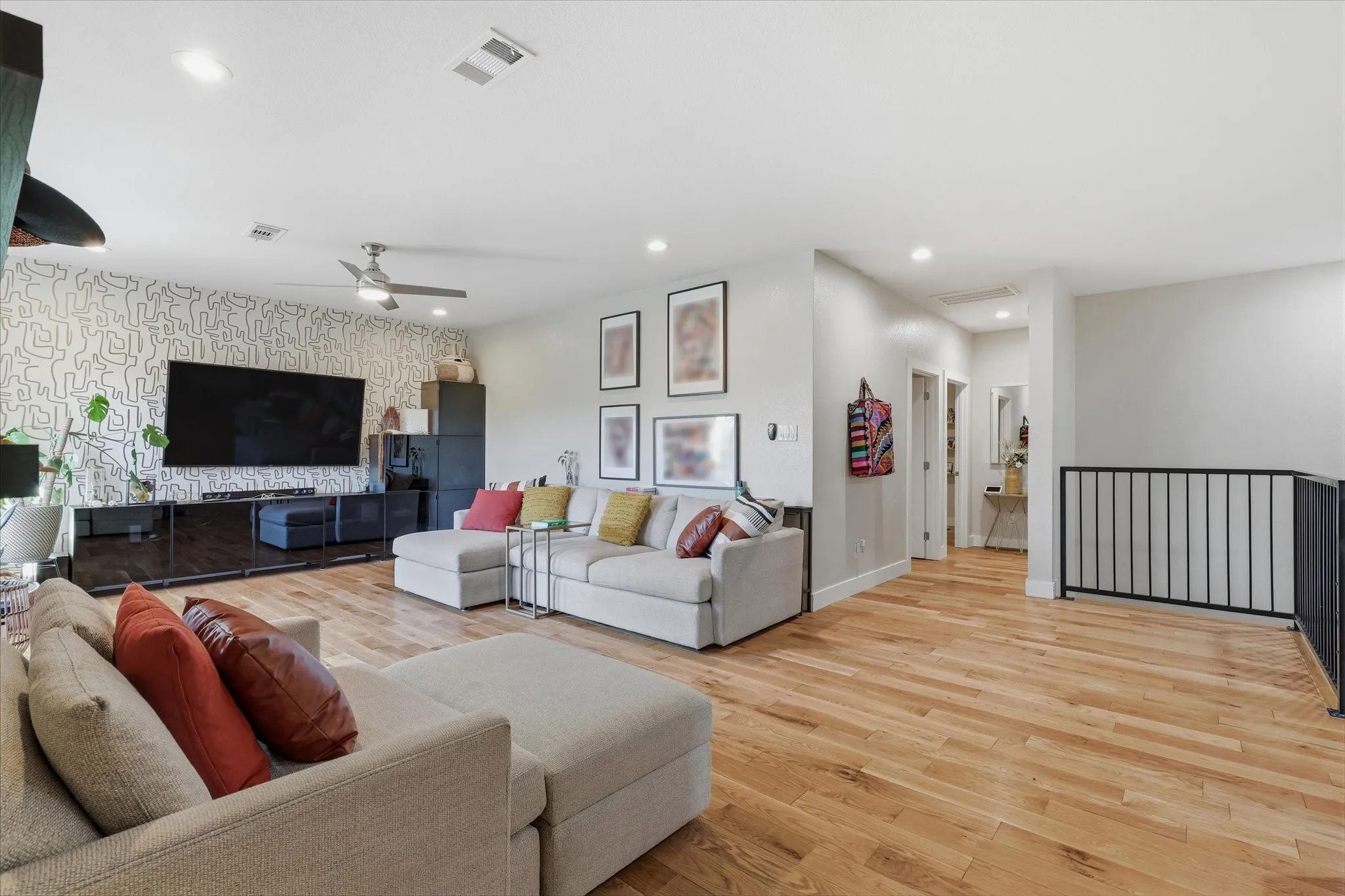 Open-concept living space featuring wood-finish flooring, recessed lighting, and a ceiling fan