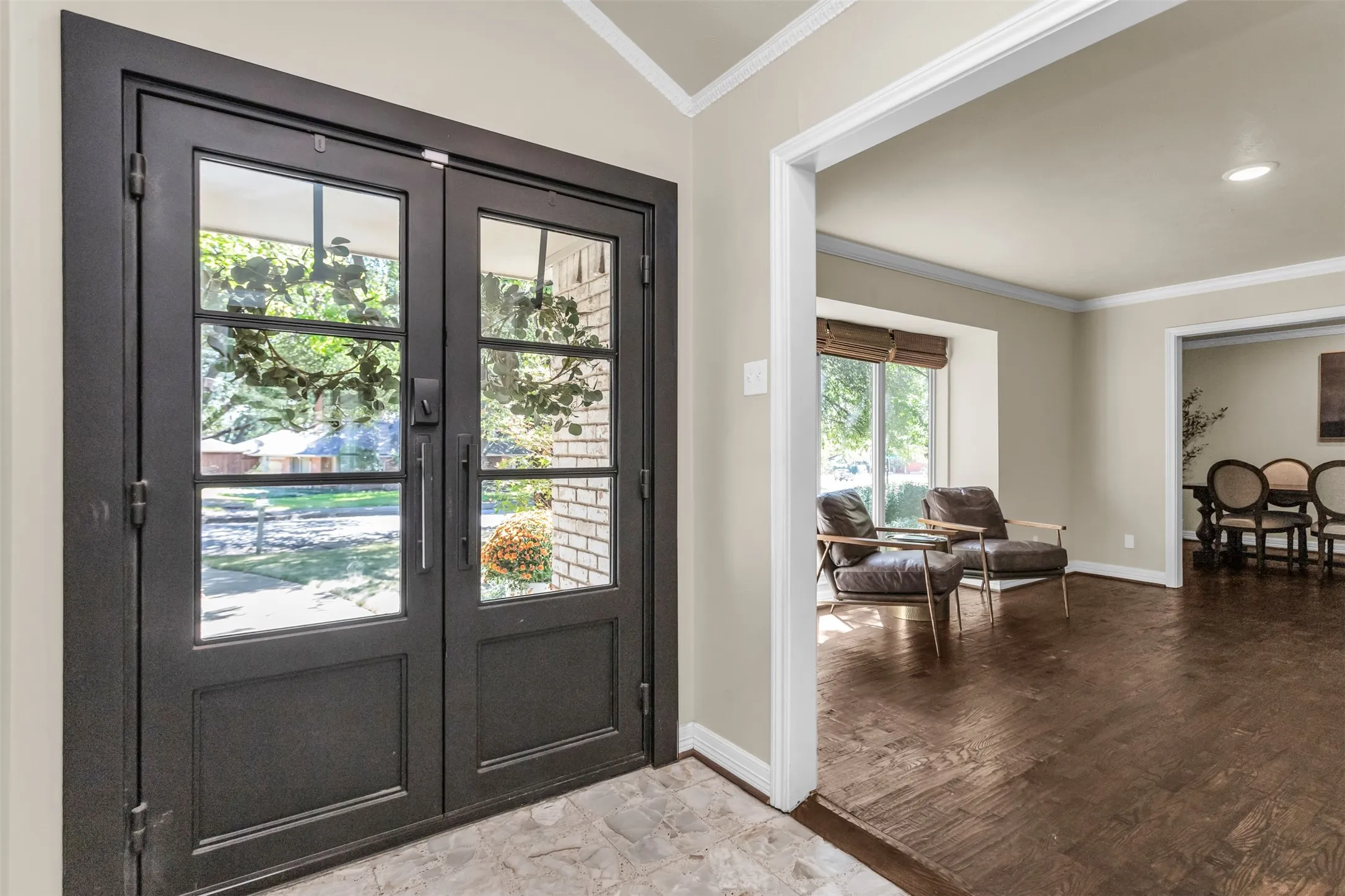 Double-entry doors with glass panes, crown molding, a recessed ceiling light, and wood-finish flooring