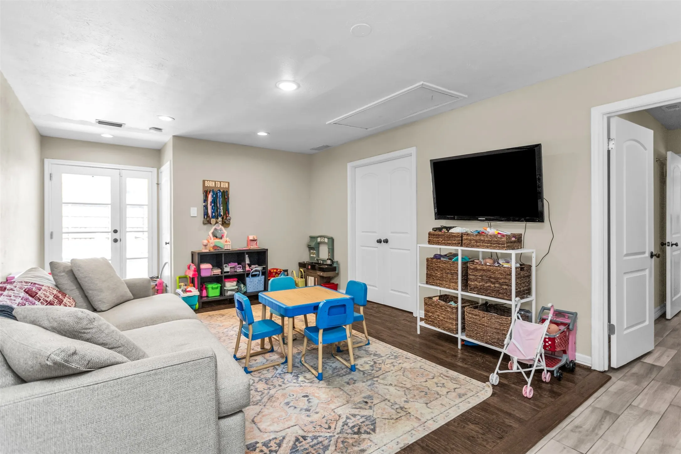 Recessed lighting, wood-finish flooring, and white double doors