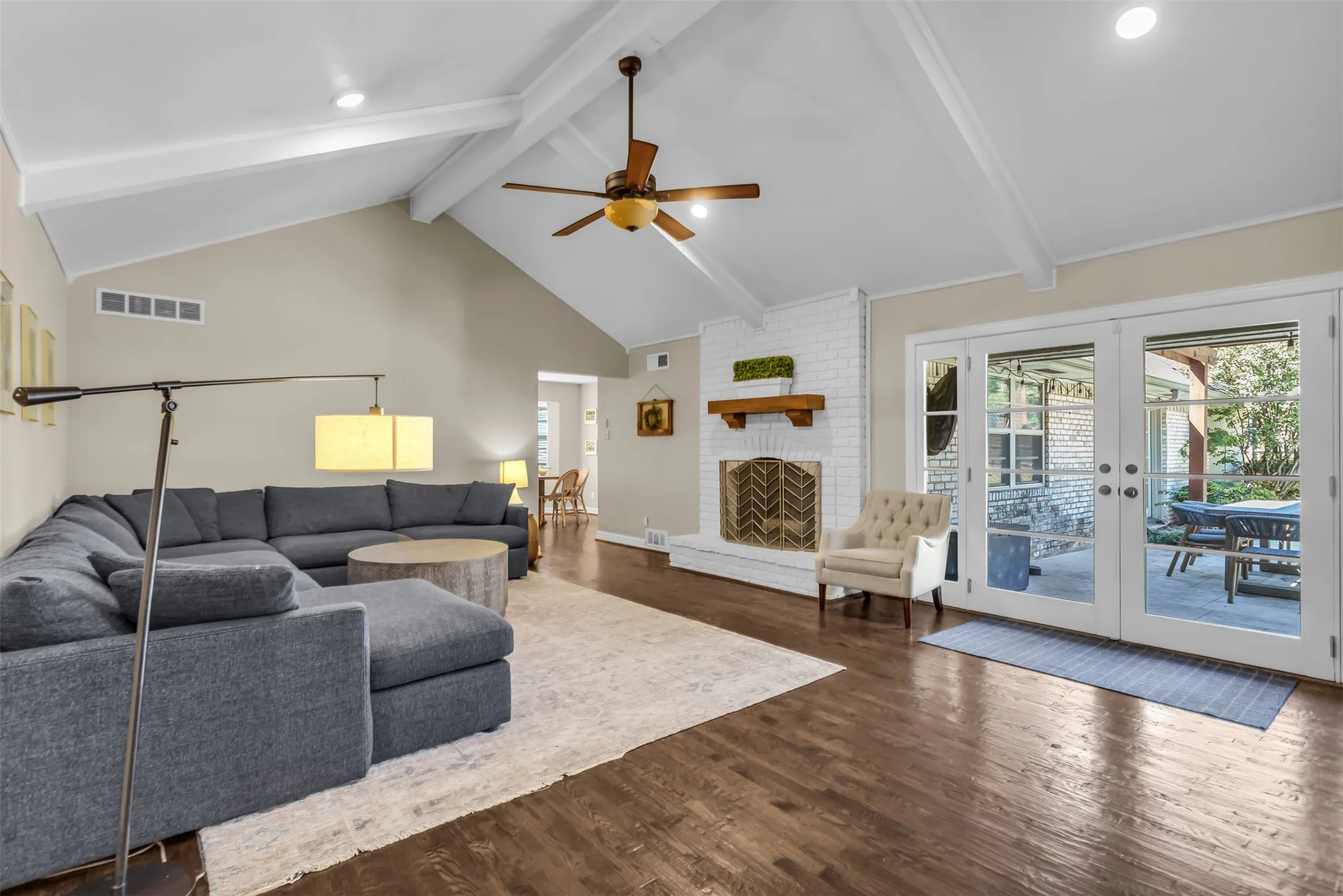 Expansive open-concept living area featuring cathedral ceilings, recessed lighting, and a ceiling fan