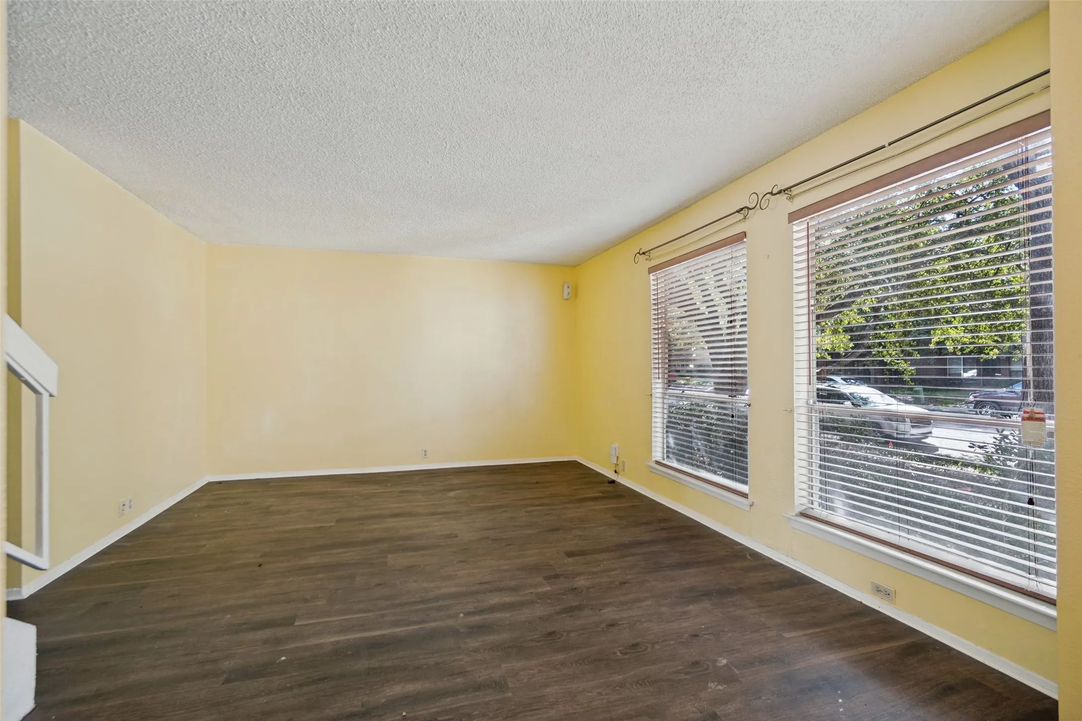 Spacious interior with wood-finish flooring, multiple windows, and a built-in fireplace structure