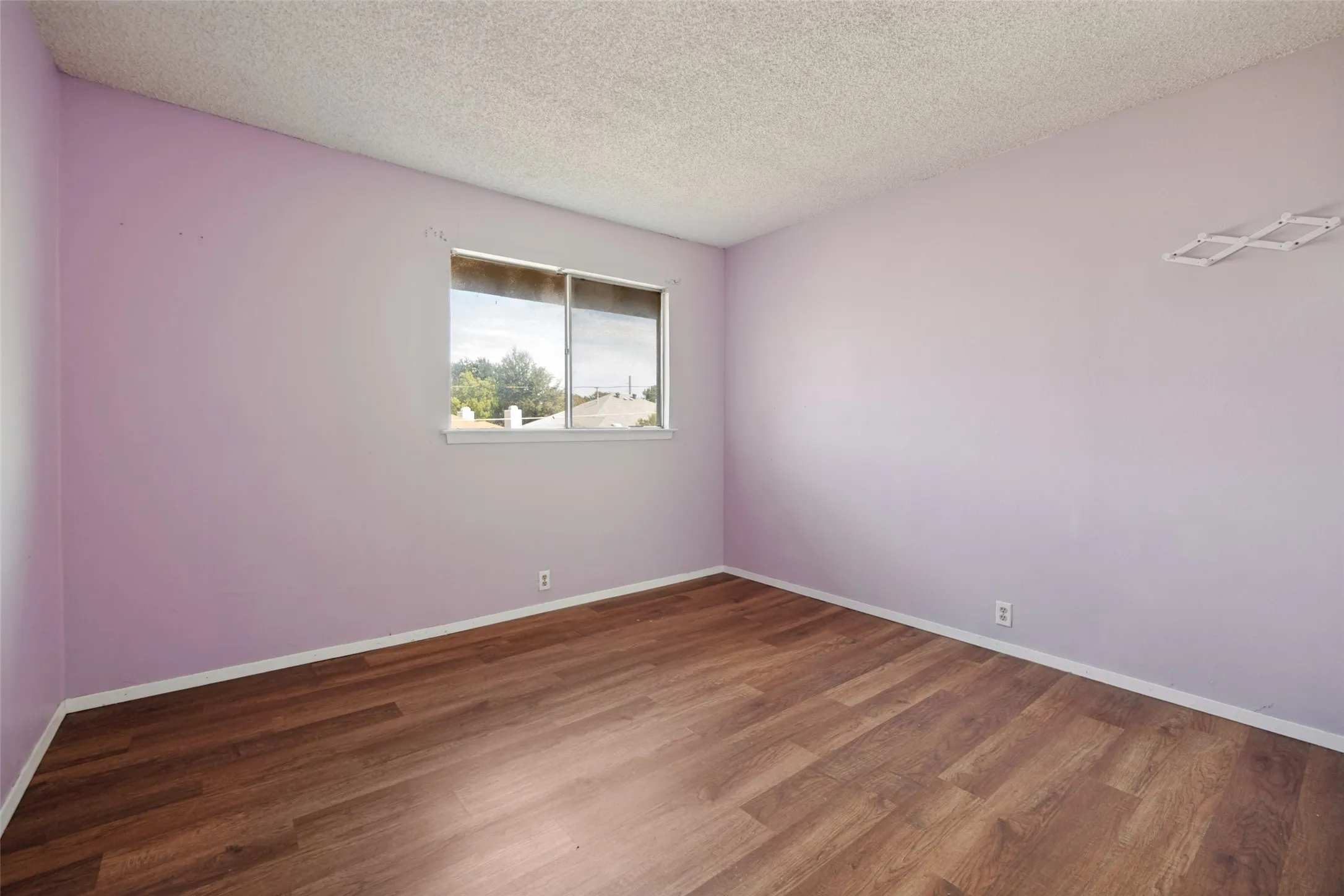 Wood-finish flooring, single window, and light-colored walls