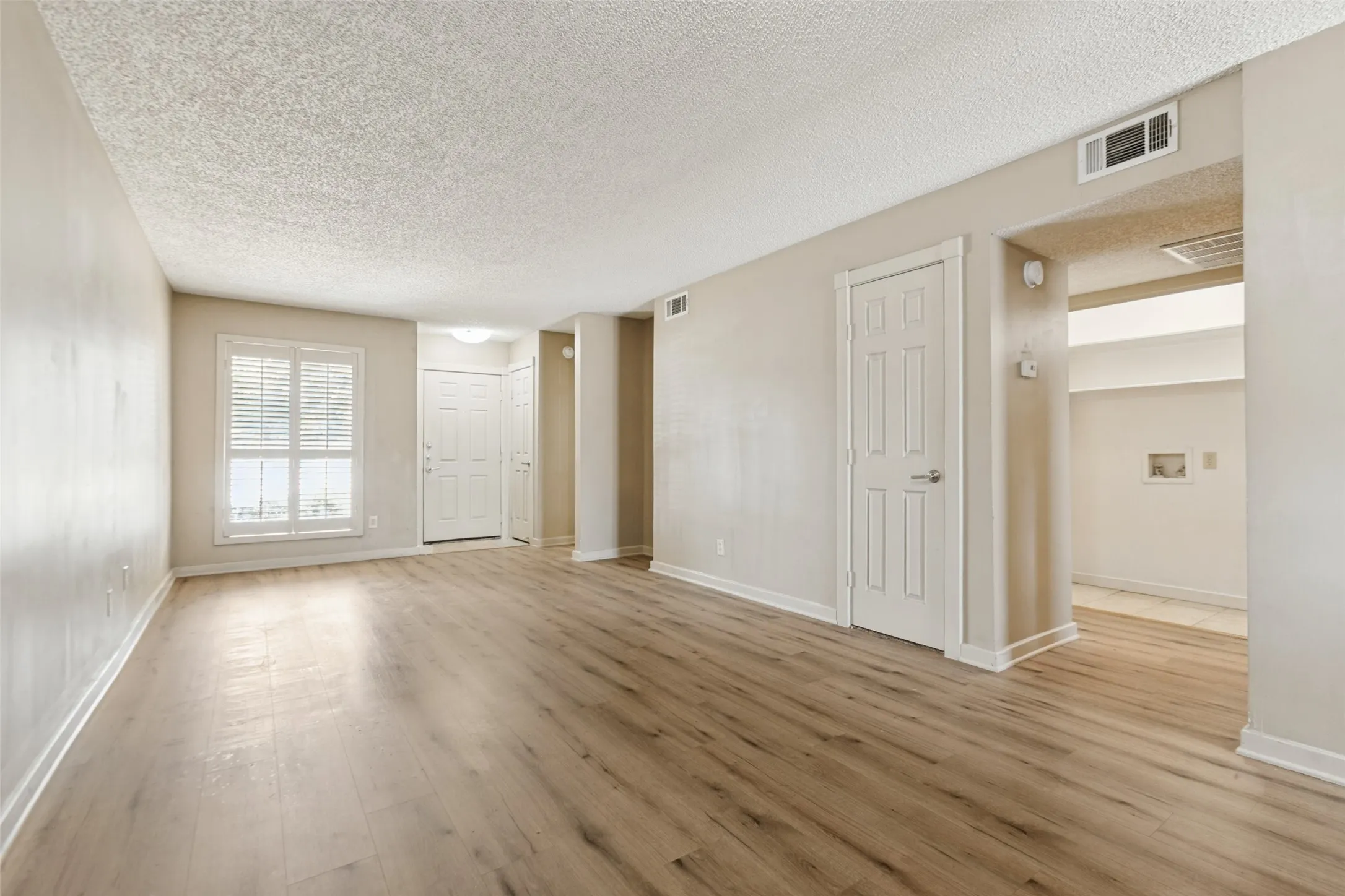 Wood-finish flooring throughout, neutral wall tones, and white trim