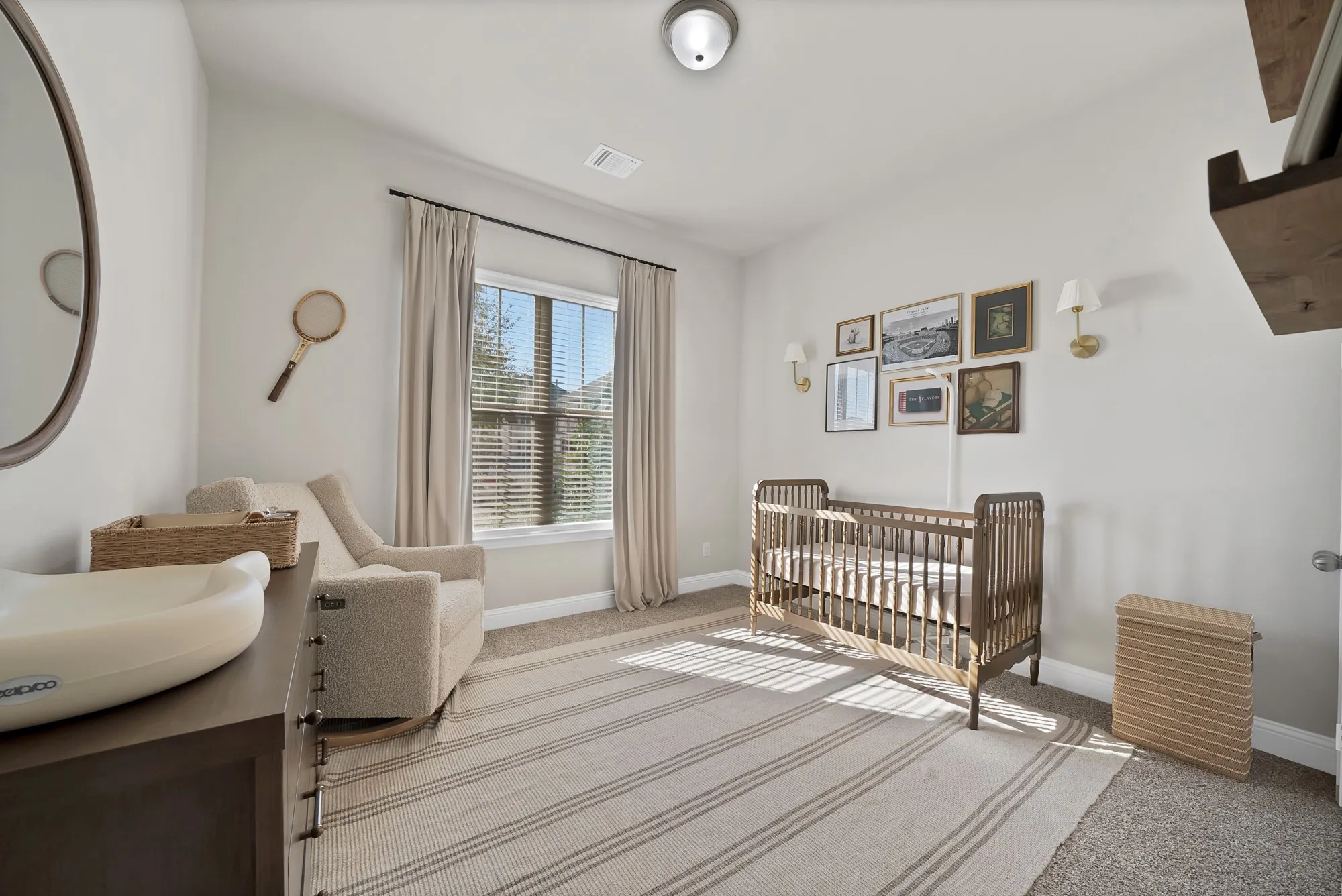 Recessed ceiling light fixture, large window with blinds and drapes, and wall-mounted sconces