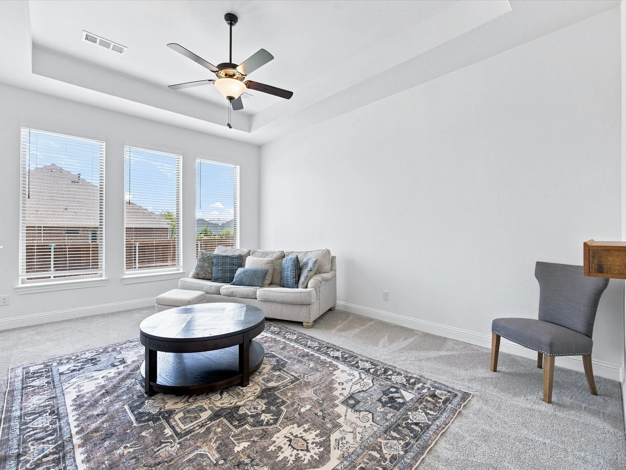 Open-concept living area with light wood-finish flooring, vaulted ceilings, and recessed lighting