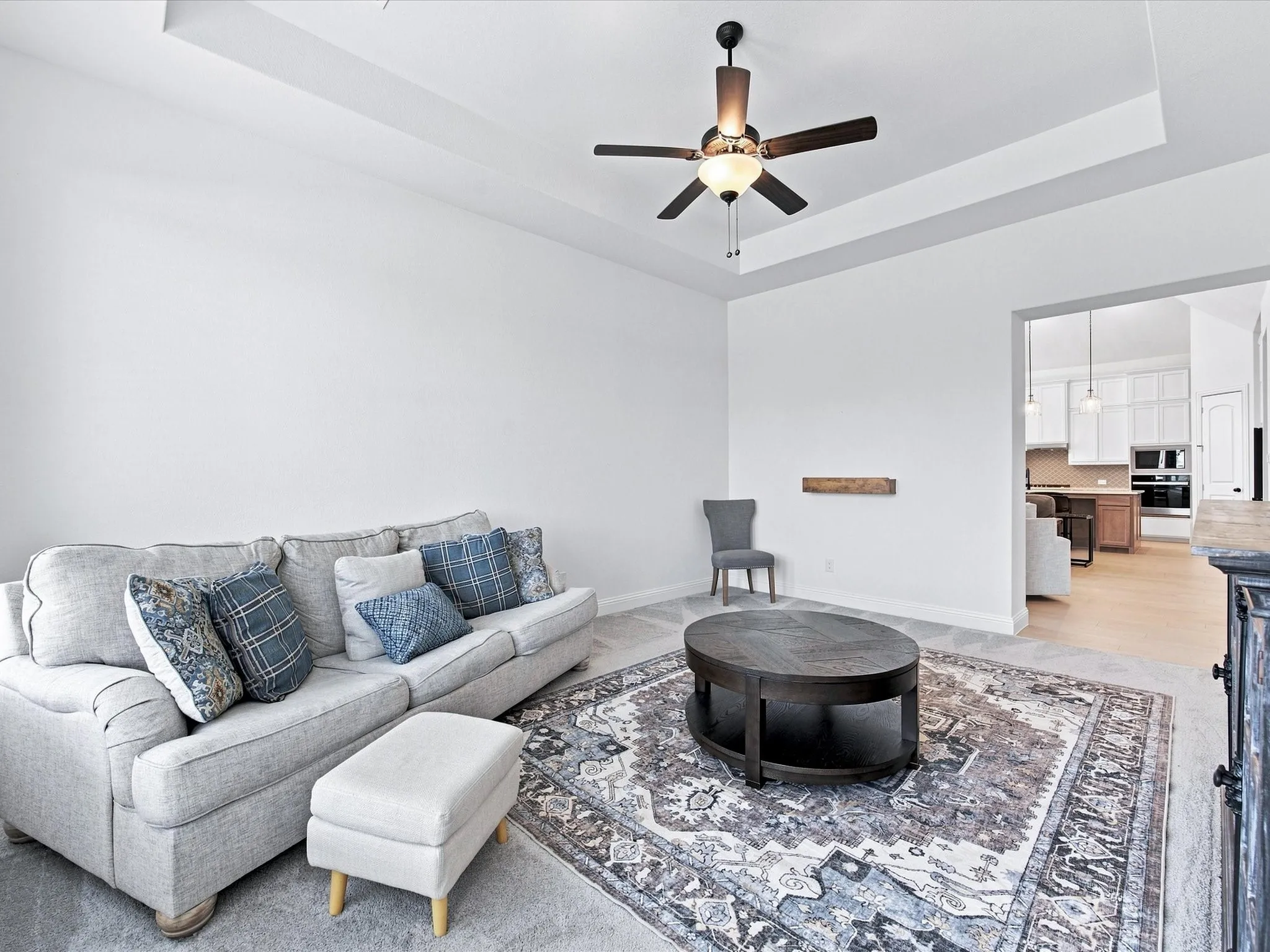Recessed lighting, tray ceiling, ceiling fan, and light wood-finish flooring
