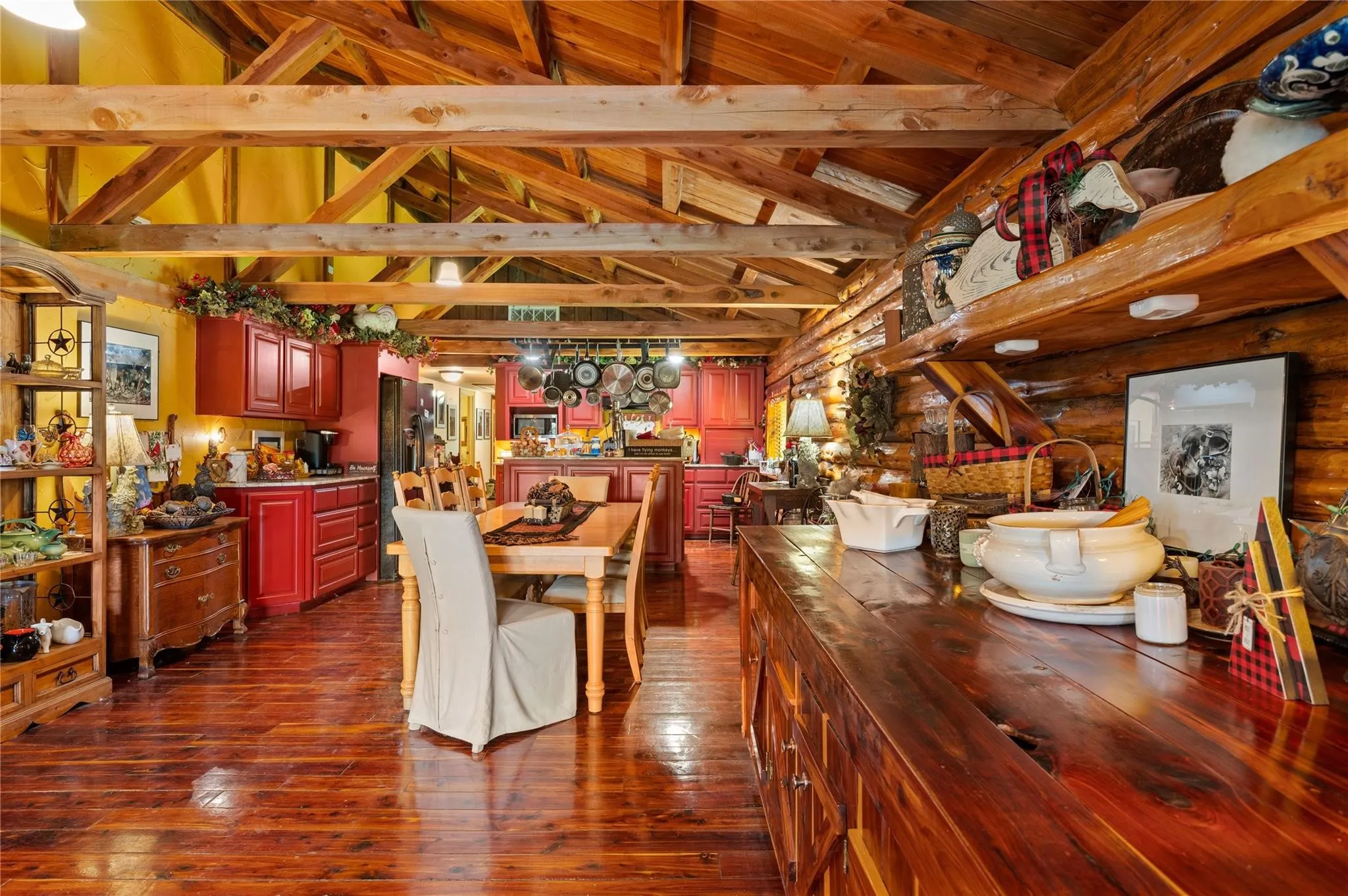 Wood-finish flooring, exposed wood beam ceiling, red & cedar built-in cabinetry, and log wall construction.