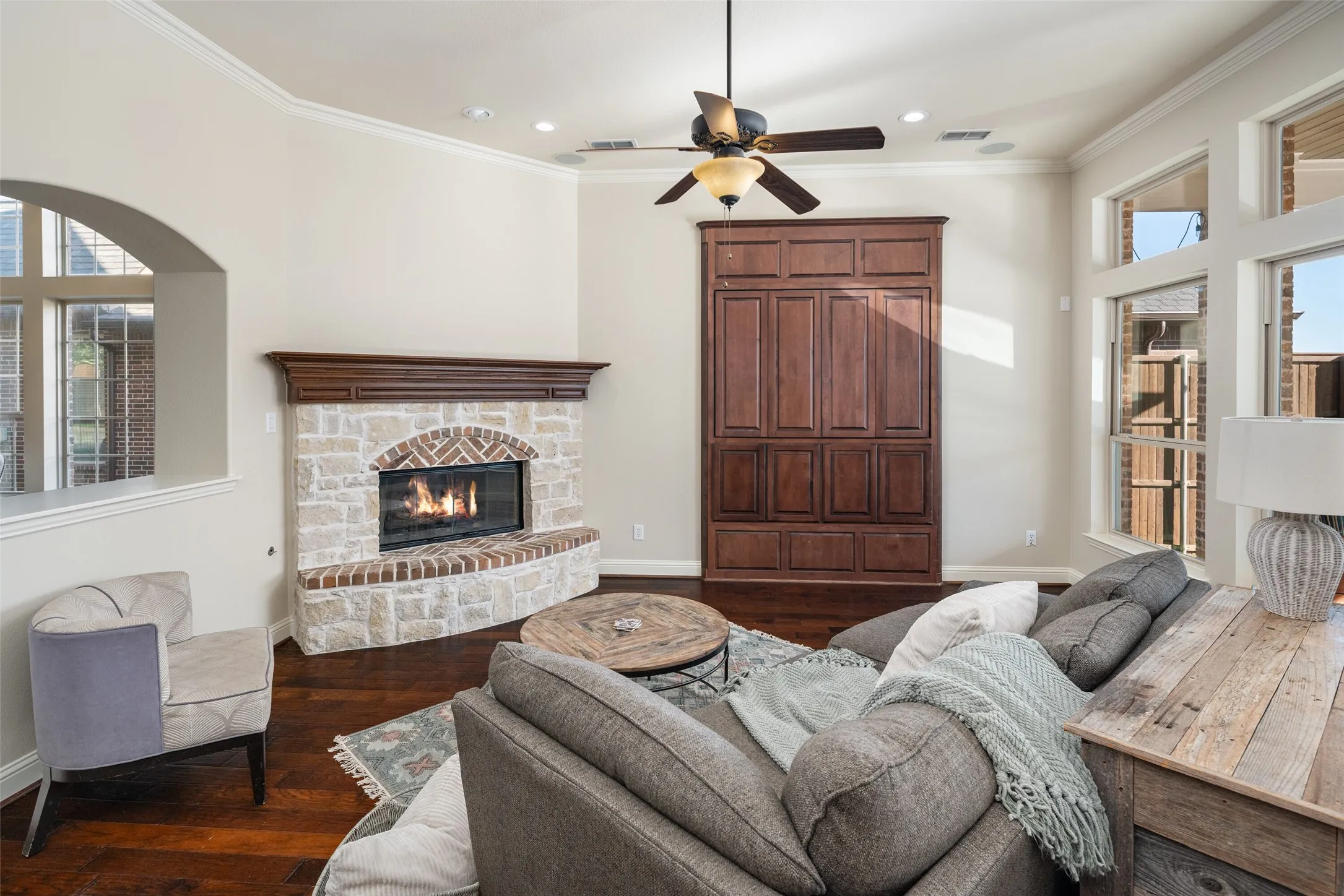 Stone and brick fireplace with a wood mantle