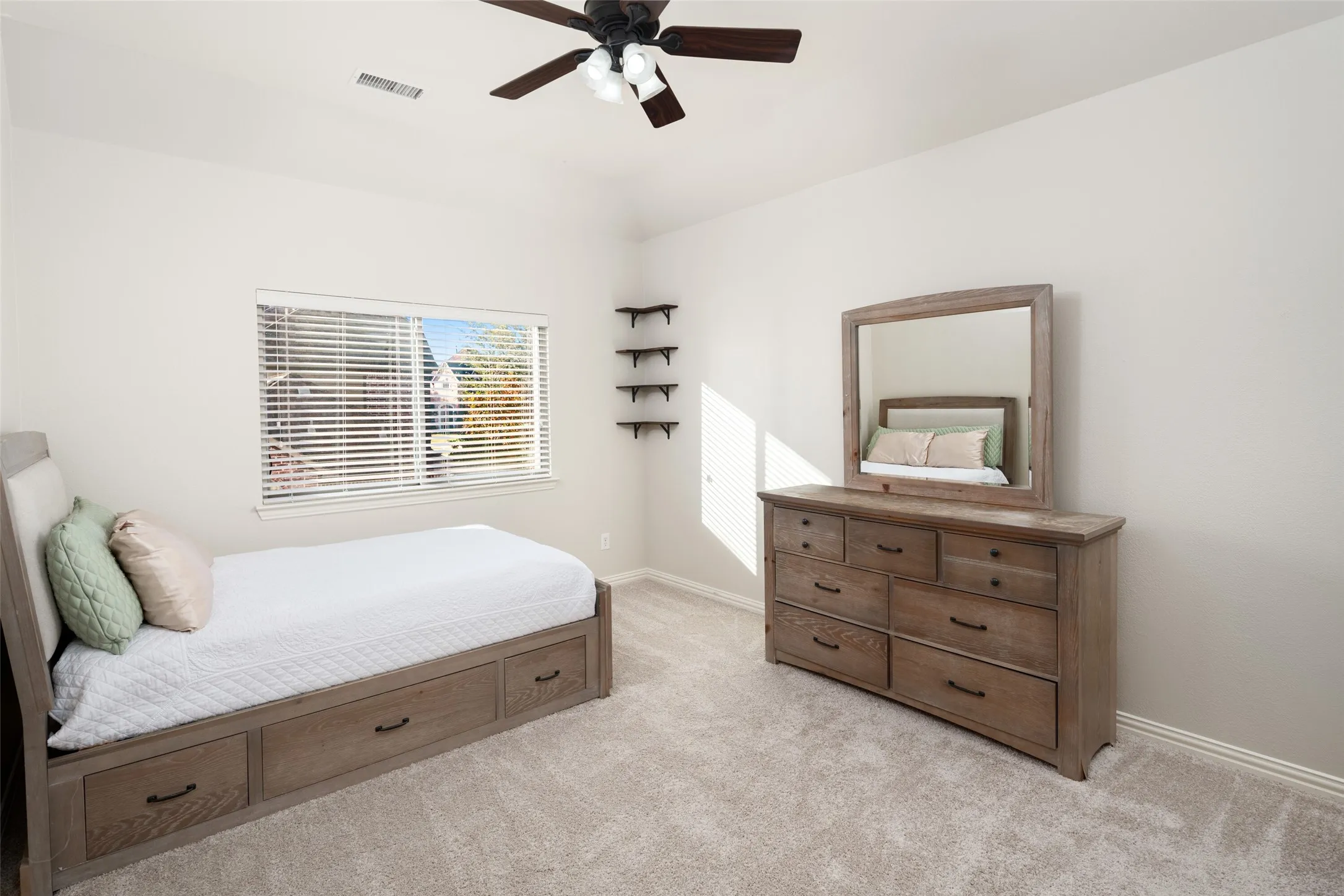 Recessed window with blinds, ceiling fan with integrated lighting, and neutral carpeting