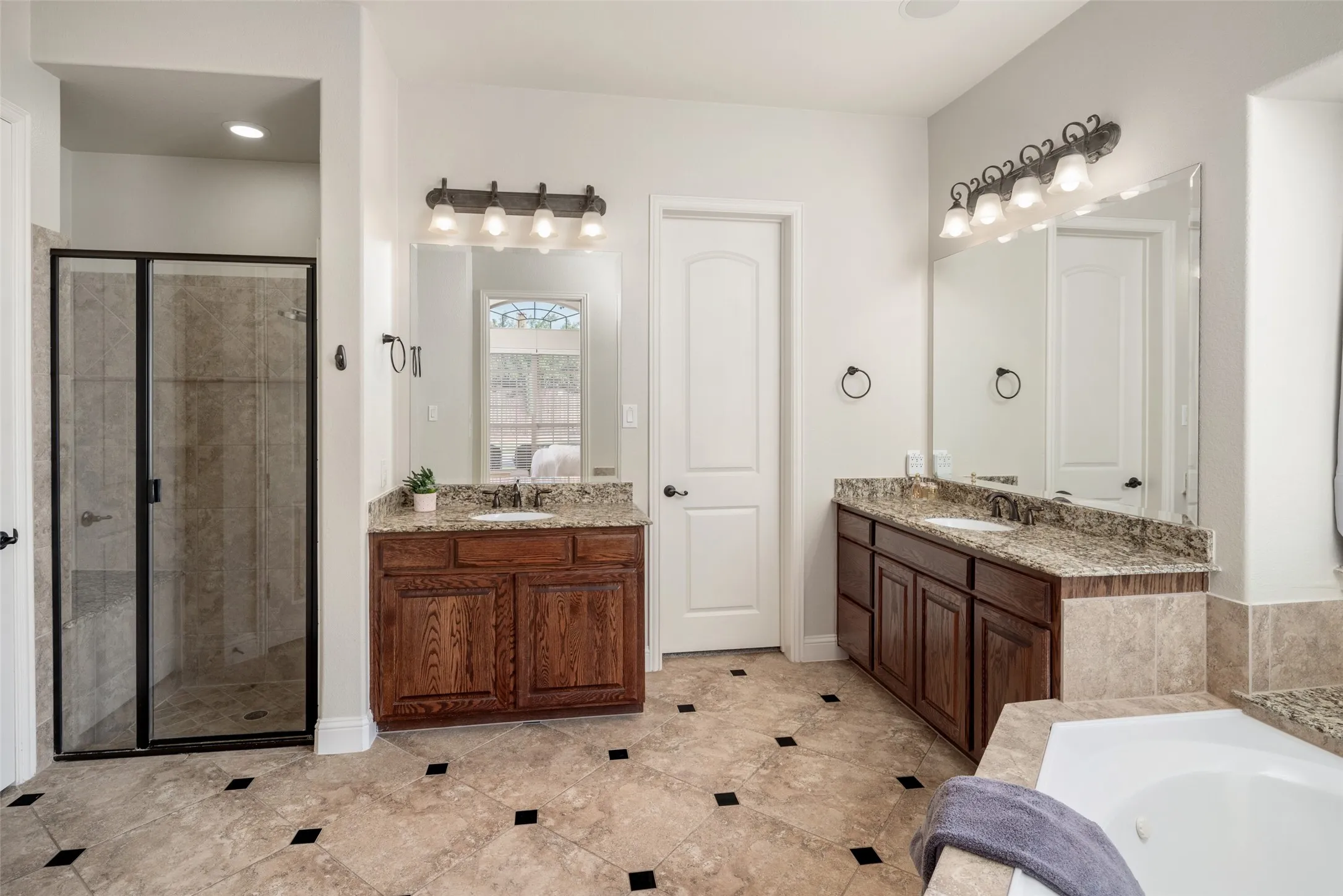 Dual vanity with wood-finish cabinetry and stone countertops