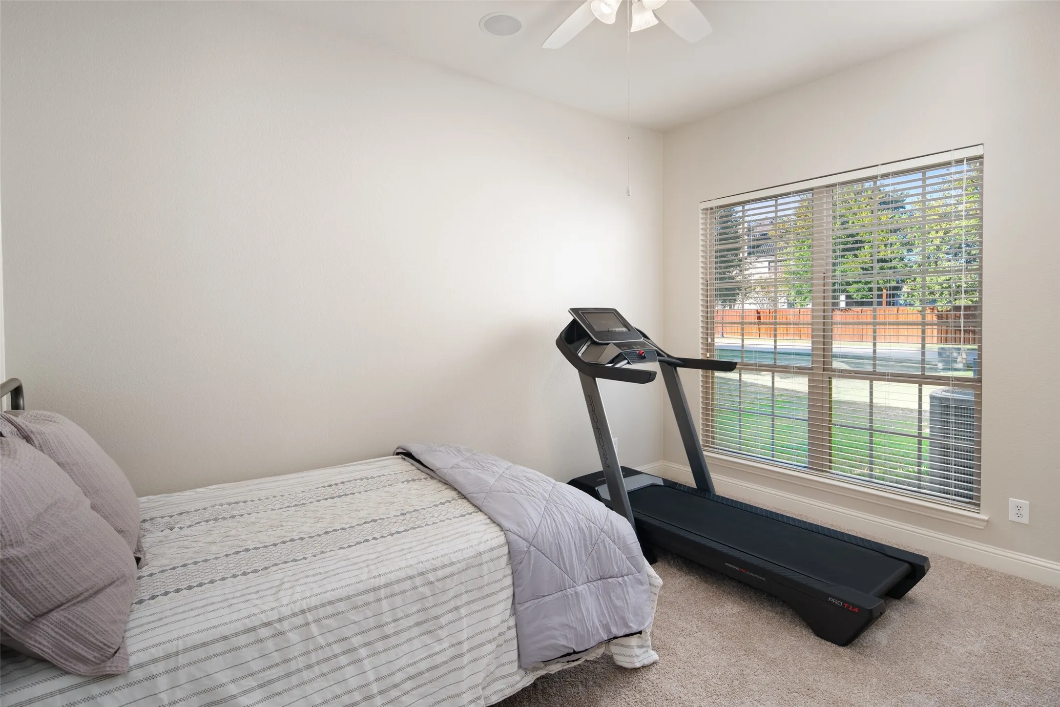 Carpeted room featuring a ceiling fan, a large window with blinds, and recessed lighting