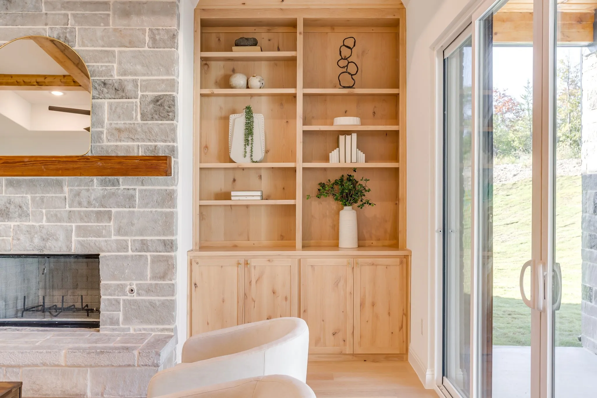 Custom built-ins by the stone fireplace with Cedar mantel
