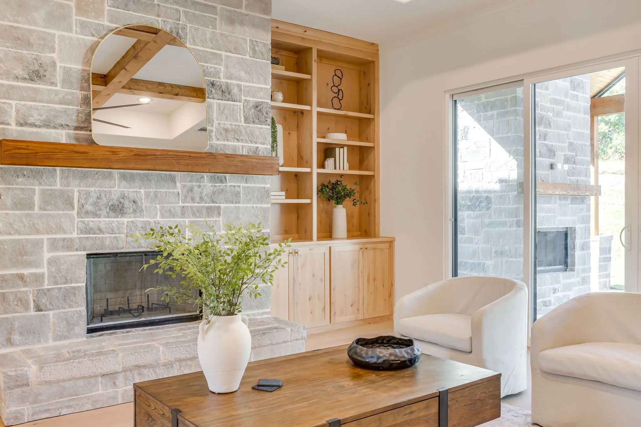 Custom built-ins by the stone fireplace with Cedar mantel
